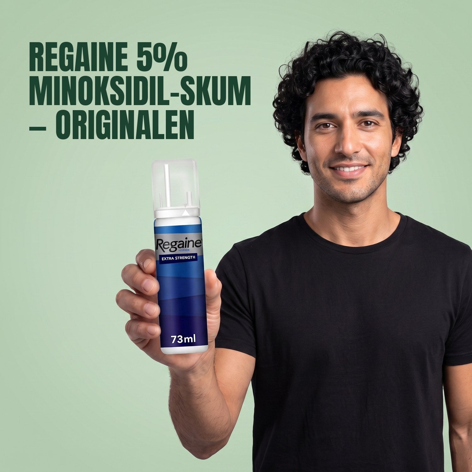 Man holding the Regaine for Men Minoxidil 5% foam pack against a green background
