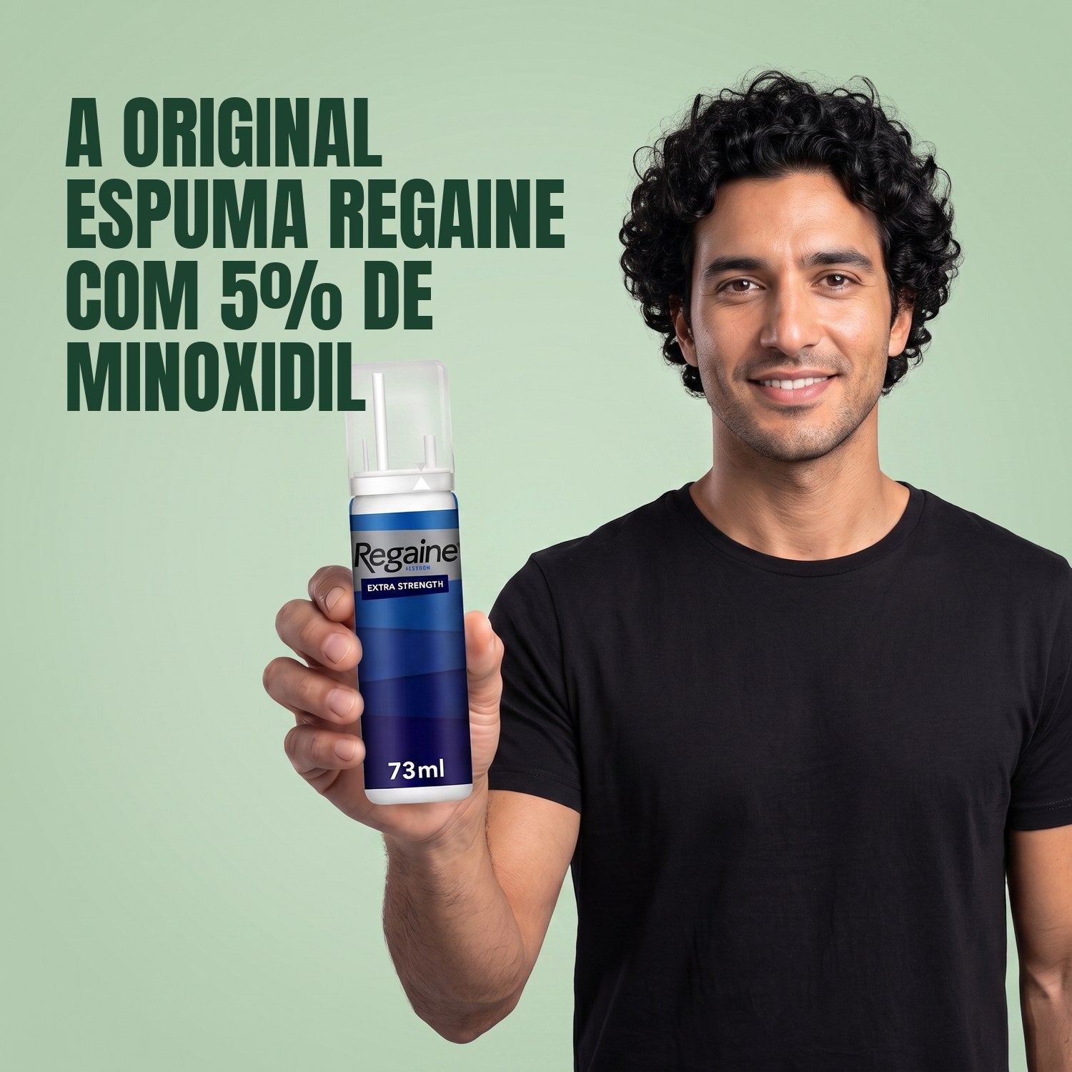 Homem segurando a embalagem de espuma Regaine for Men Minoxidil 5% em fundo verde