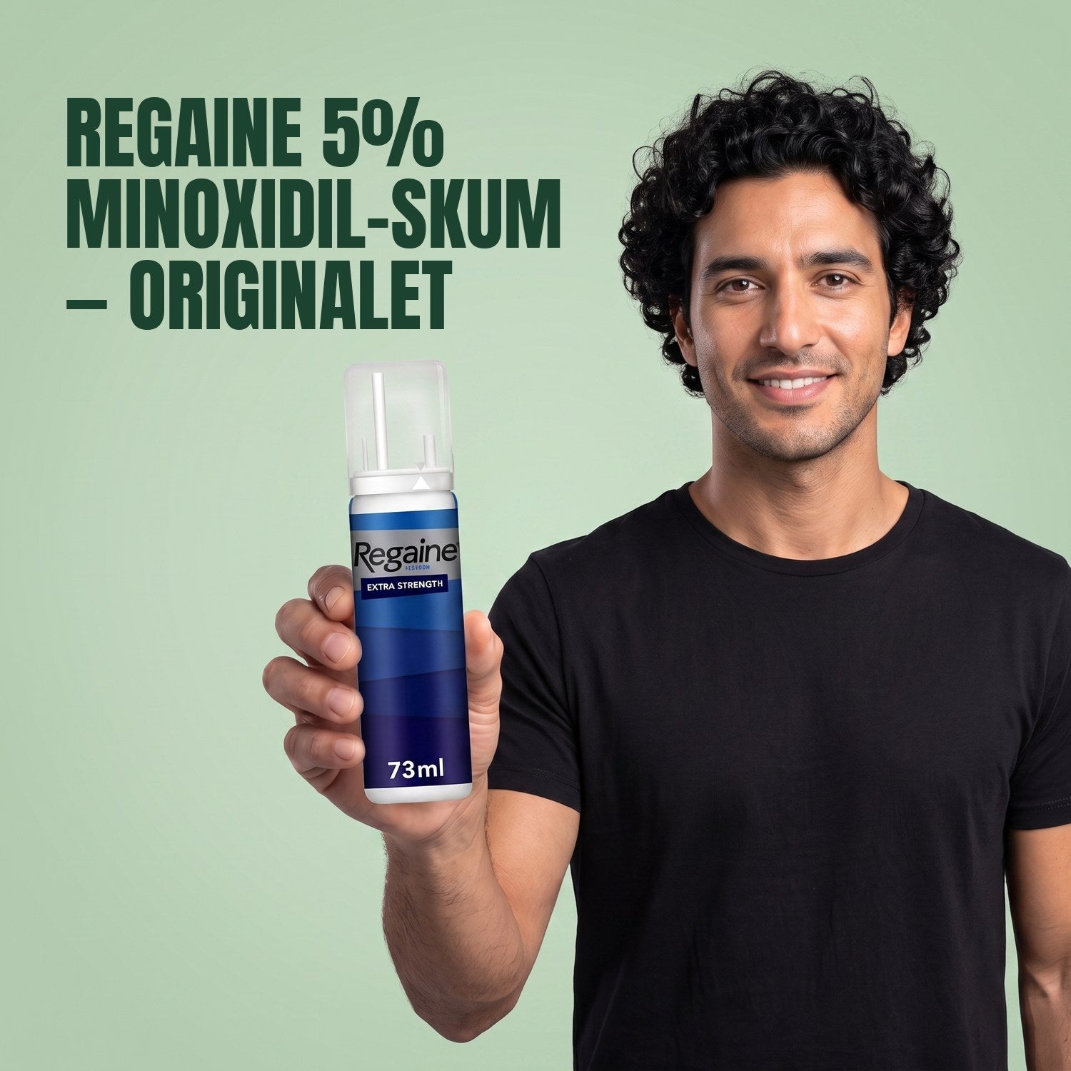 Man holding the Regaine for Men Minoxidil 5% foam pack against a green background