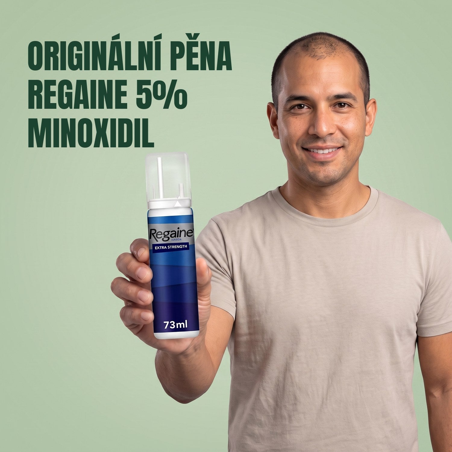 Man holding the Regaine for Men Minoxidil 5% foam pack against a green background