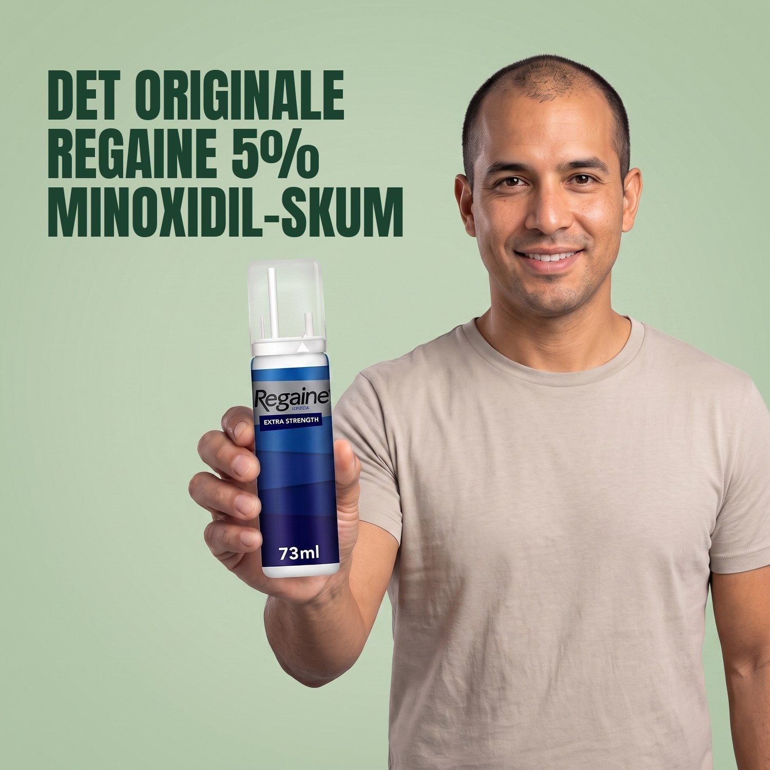 Man holding the Regaine for Men Minoxidil 5% foam pack against a green background