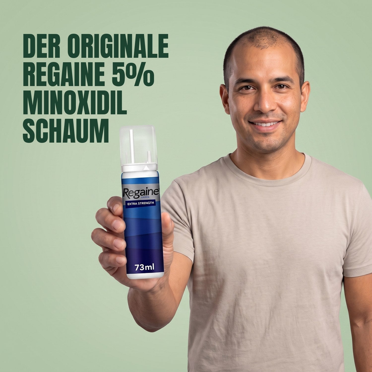 Man holding the Regaine for Men Minoxidil 5% foam pack against a green background