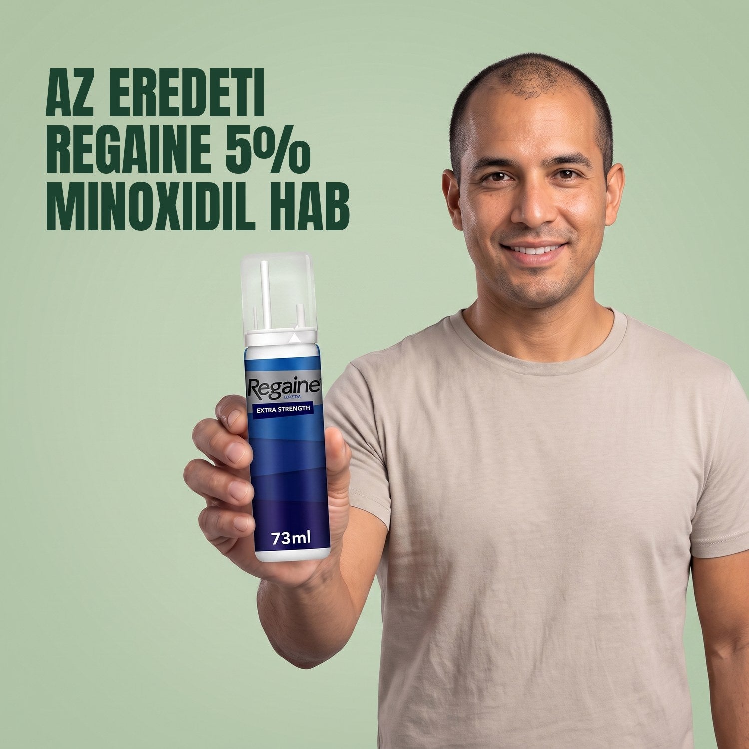 Man holding the Regaine for Men Minoxidil 5% foam pack against a green background