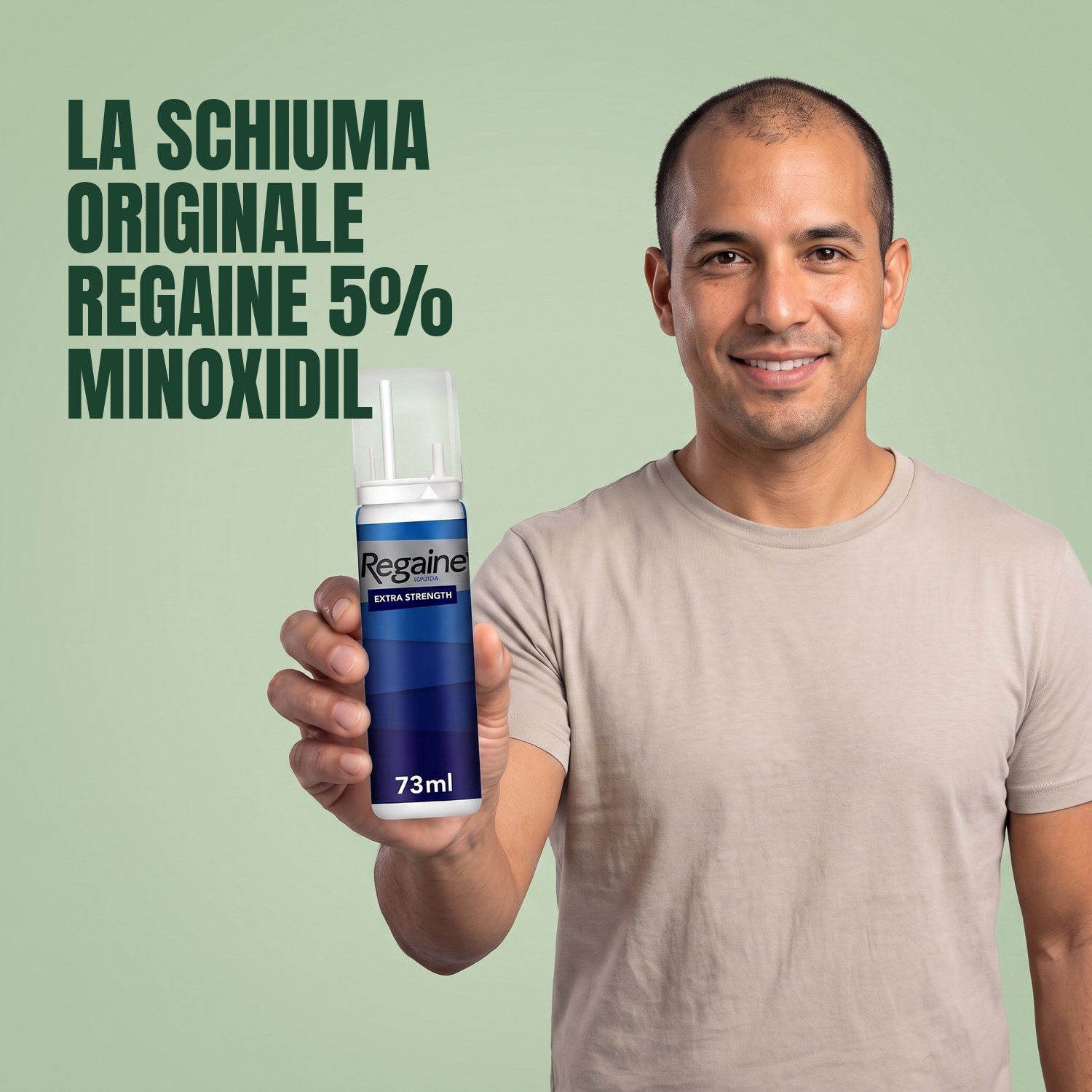 Man holding the Regaine for Men Minoxidil 5% foam pack against a green background