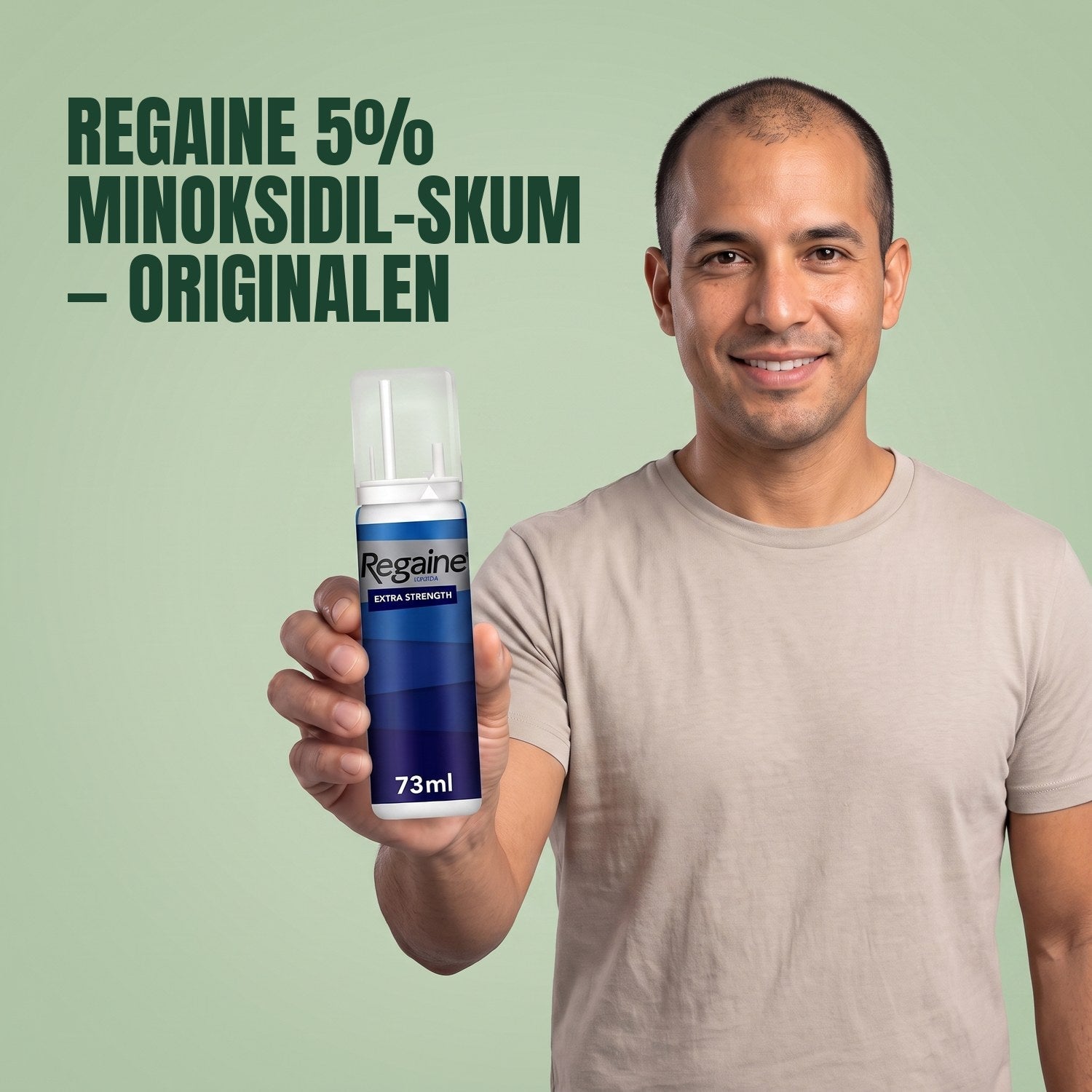 Man holding the Regaine for Men Minoxidil 5% foam pack against a green background