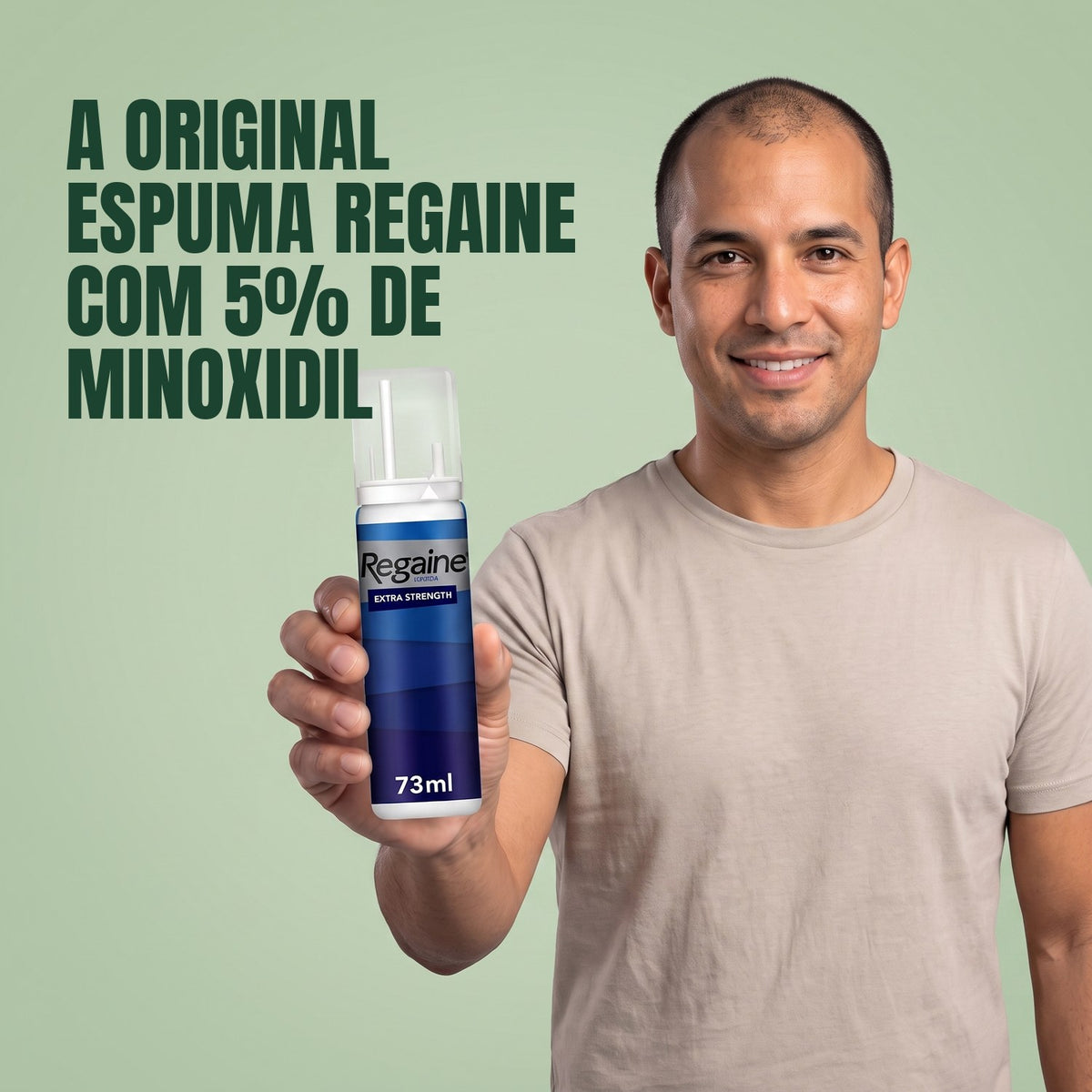Homem segurando a embalagem de espuma Regaine for Men Minoxidil 5% em fundo verde