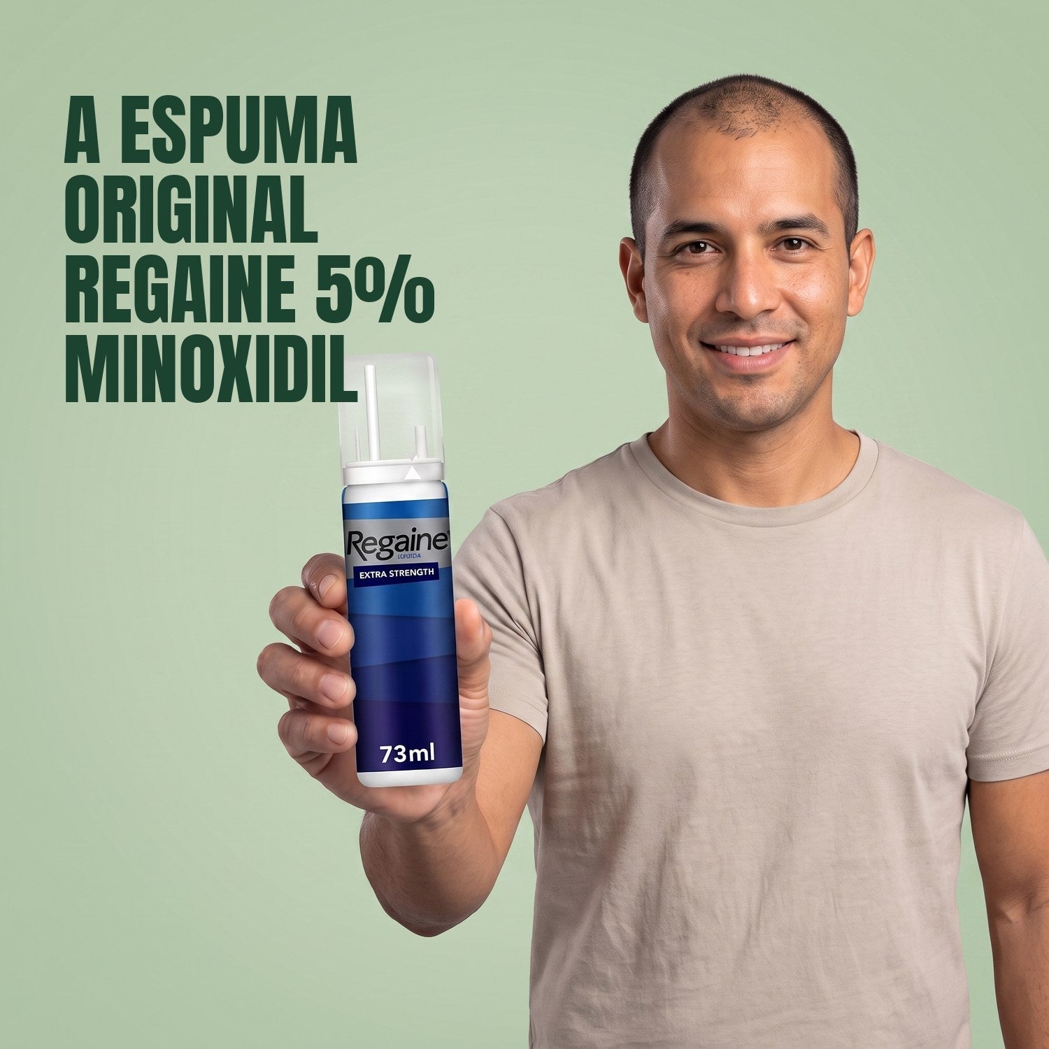 Man holding the Regaine for Men Minoxidil 5% foam pack against a green background