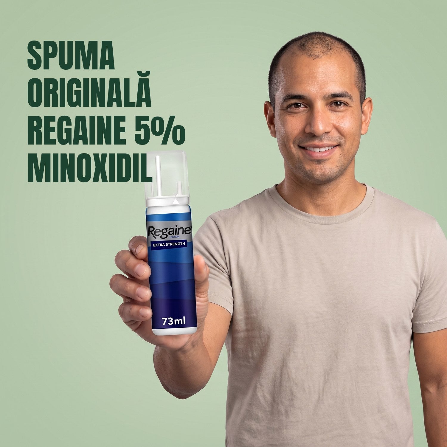 Man holding the Regaine for Men Minoxidil 5% foam pack against a green background