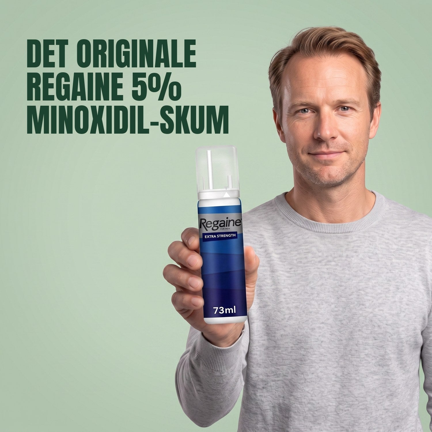Man holding the Regaine for Men Minoxidil 5% foam pack against a green background