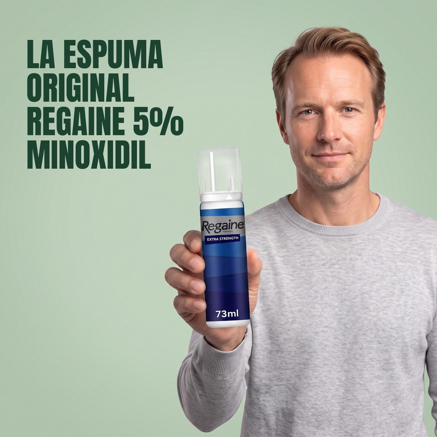 Man holding the Regaine for Men Minoxidil 5% foam pack against a green background