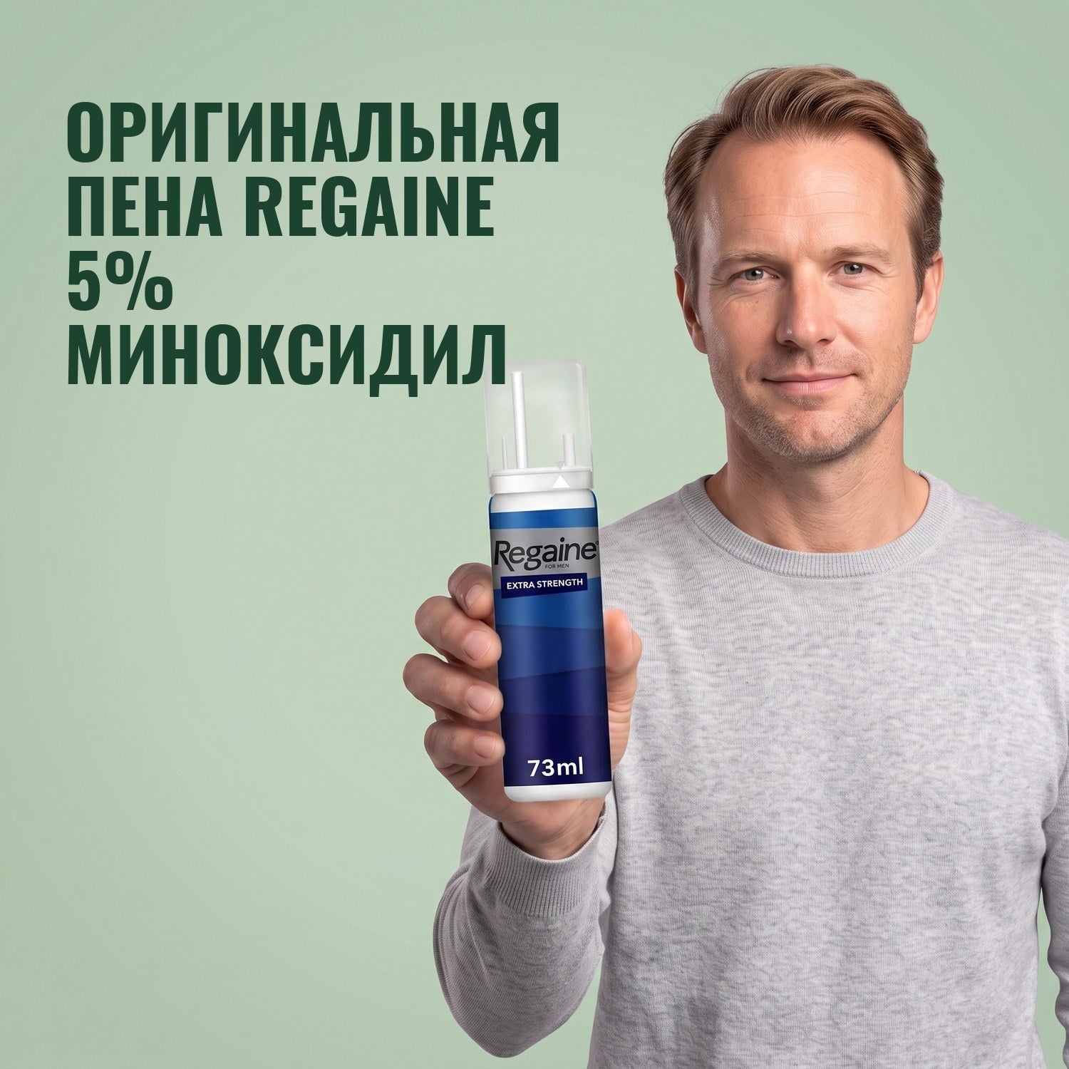 Man holding the Regaine for Men Minoxidil 5% foam pack against a green background