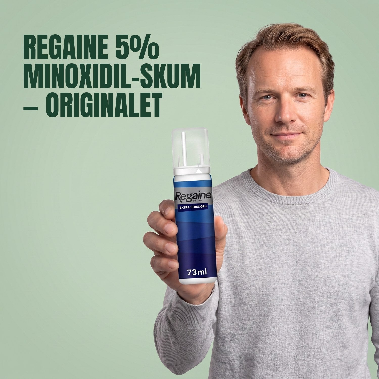 Man holding the Regaine for Men Minoxidil 5% foam pack against a green background