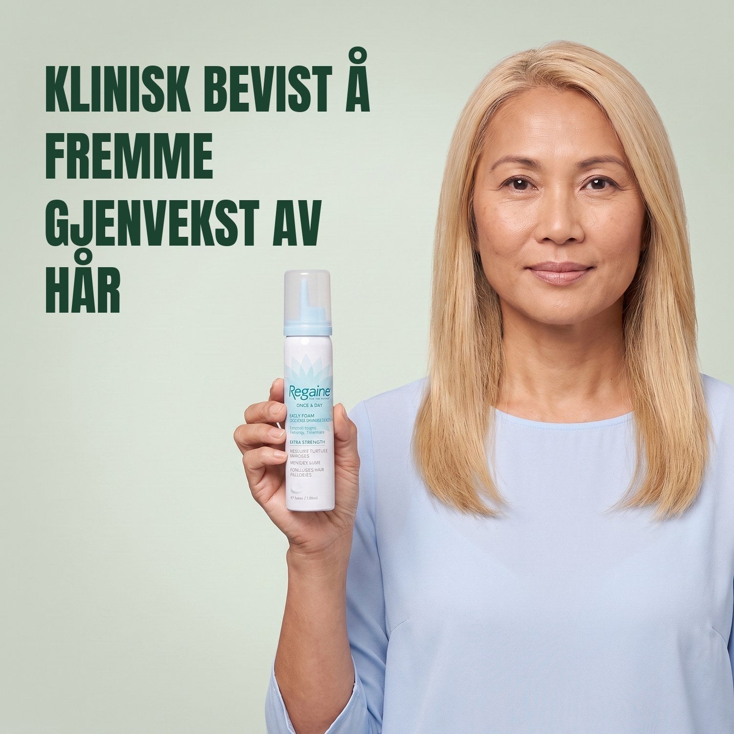Woman holding the Regaine for Women Minoxidil 5% foam carton with a foam can against a green background