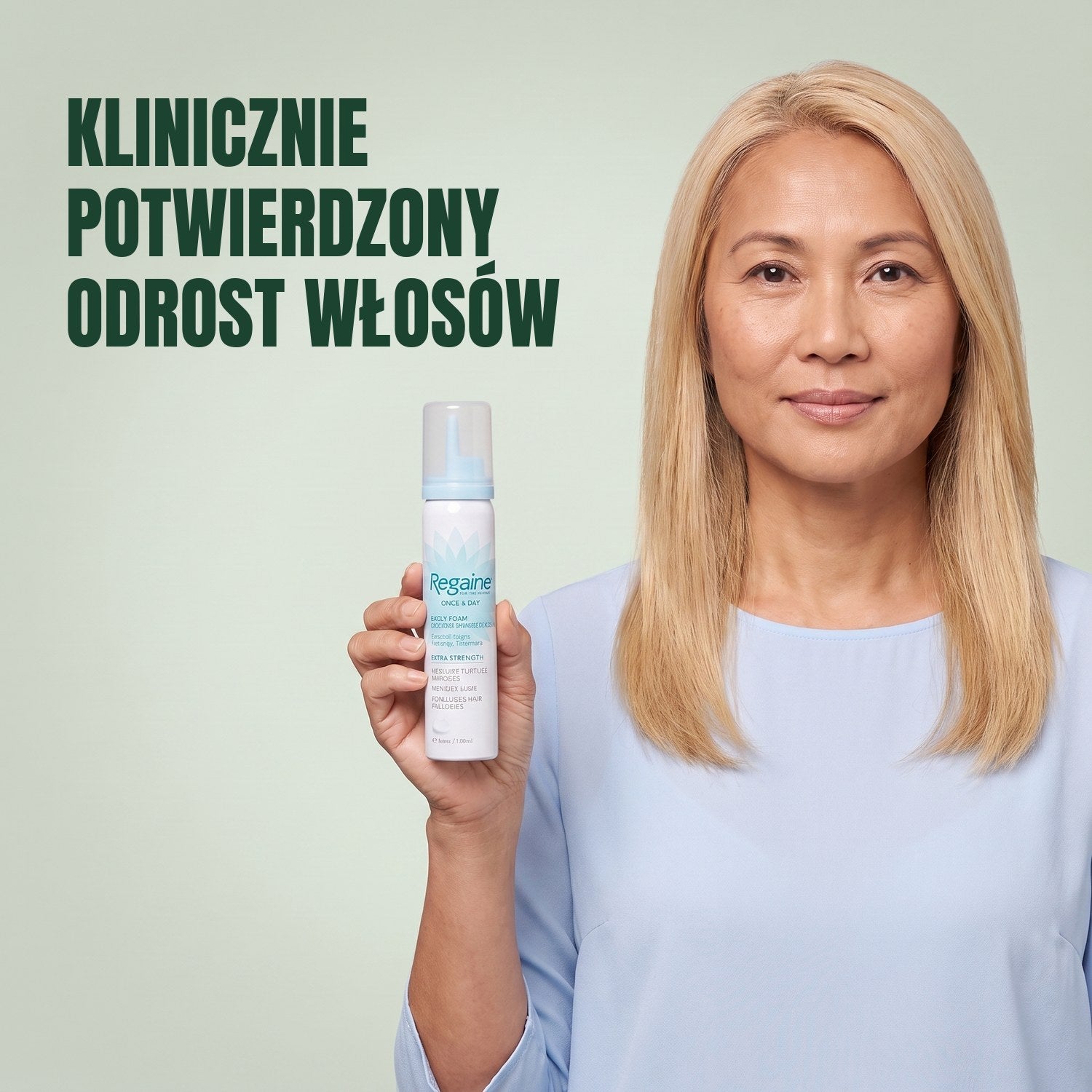 Kobieta trzyma pudełko pianki Regaine for Women Minoxidil 5% z puszką pianki na zielonym tle