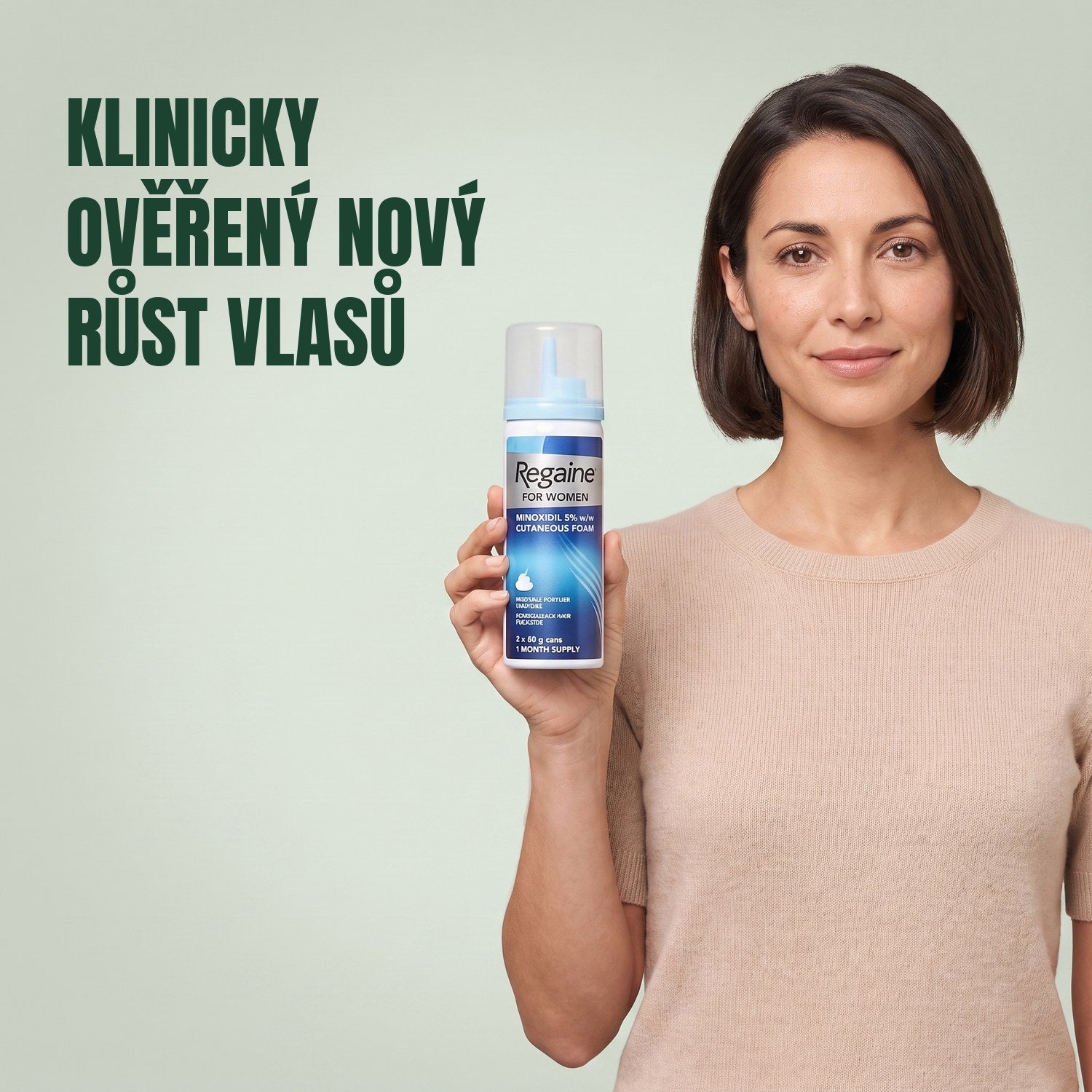 Žena drží krabičku pěny Regaine for Women Minoxidil 5% s plechovkou pěny na zeleném pozadí