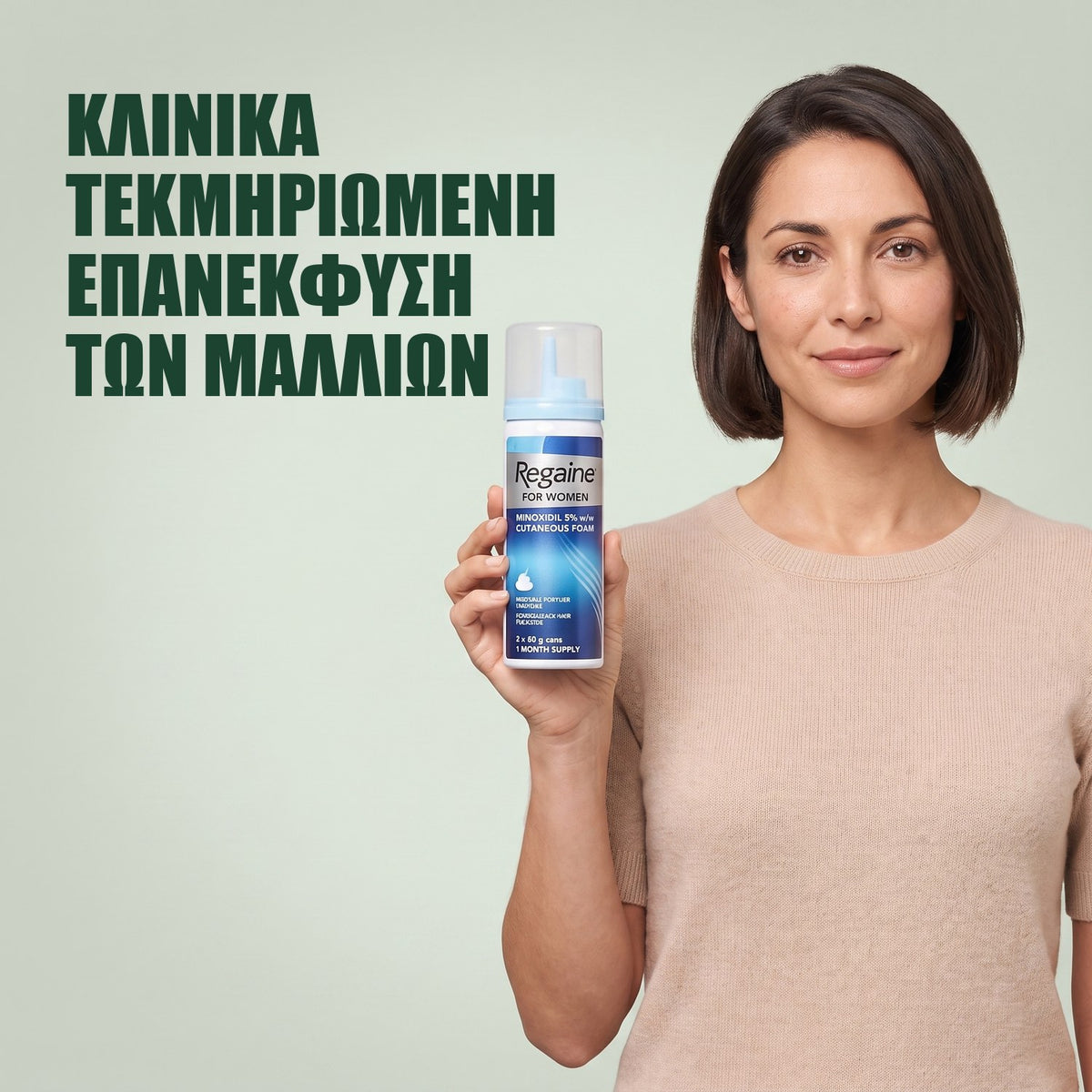 Γυναίκα κρατά το κουτί Regaine for Women Minoxidil 5% αφρός με δοχείο αφρού σε πράσινο φόντο