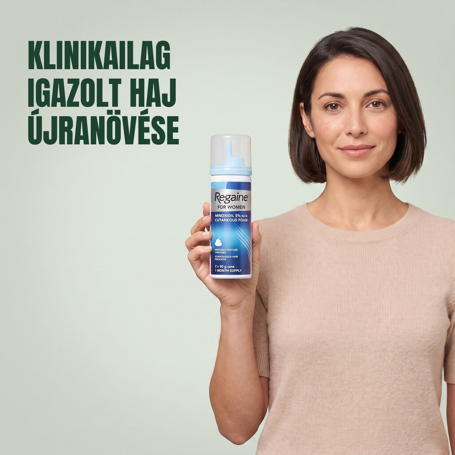 Nő tartja a Regaine for Women Minoxidil 5% hab csomagolását egy hab dobozzal, zöld háttér előtt