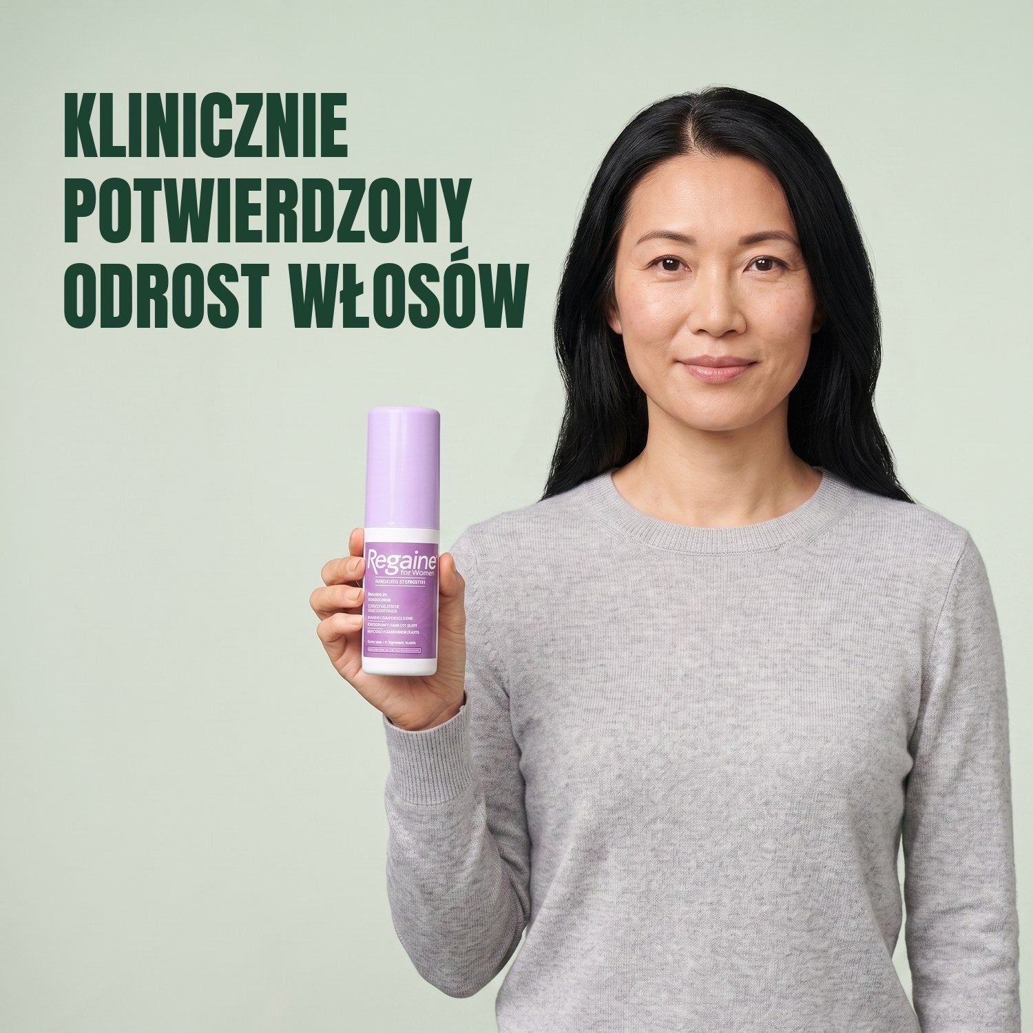 Kobieta trzyma opakowanie płynu Regaine for Women Minoxidil 2% na zielonym tle