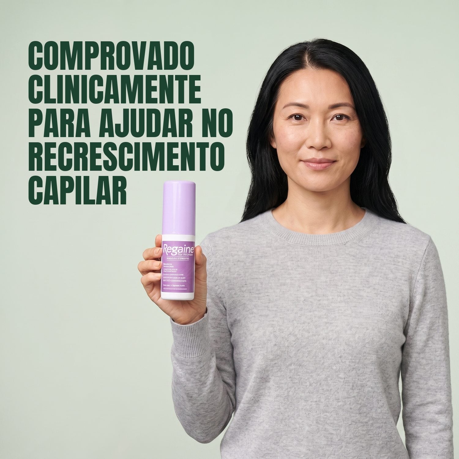 Mulher segurando a embalagem de loção Regaine for Women Minoxidil 2% em fundo verde