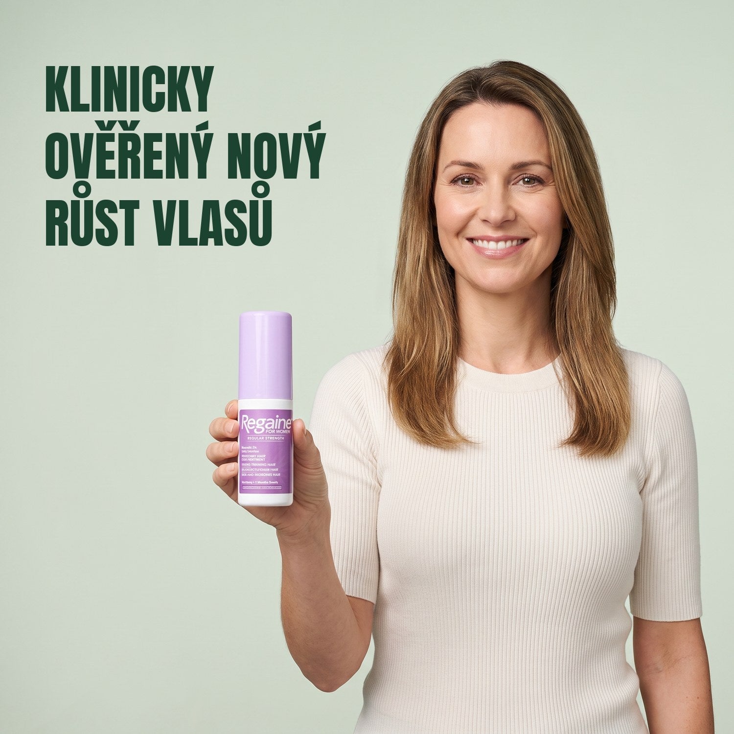 Žena drží lahvičku roztoku Regaine for Women Minoxidil 2% na zeleném pozadí