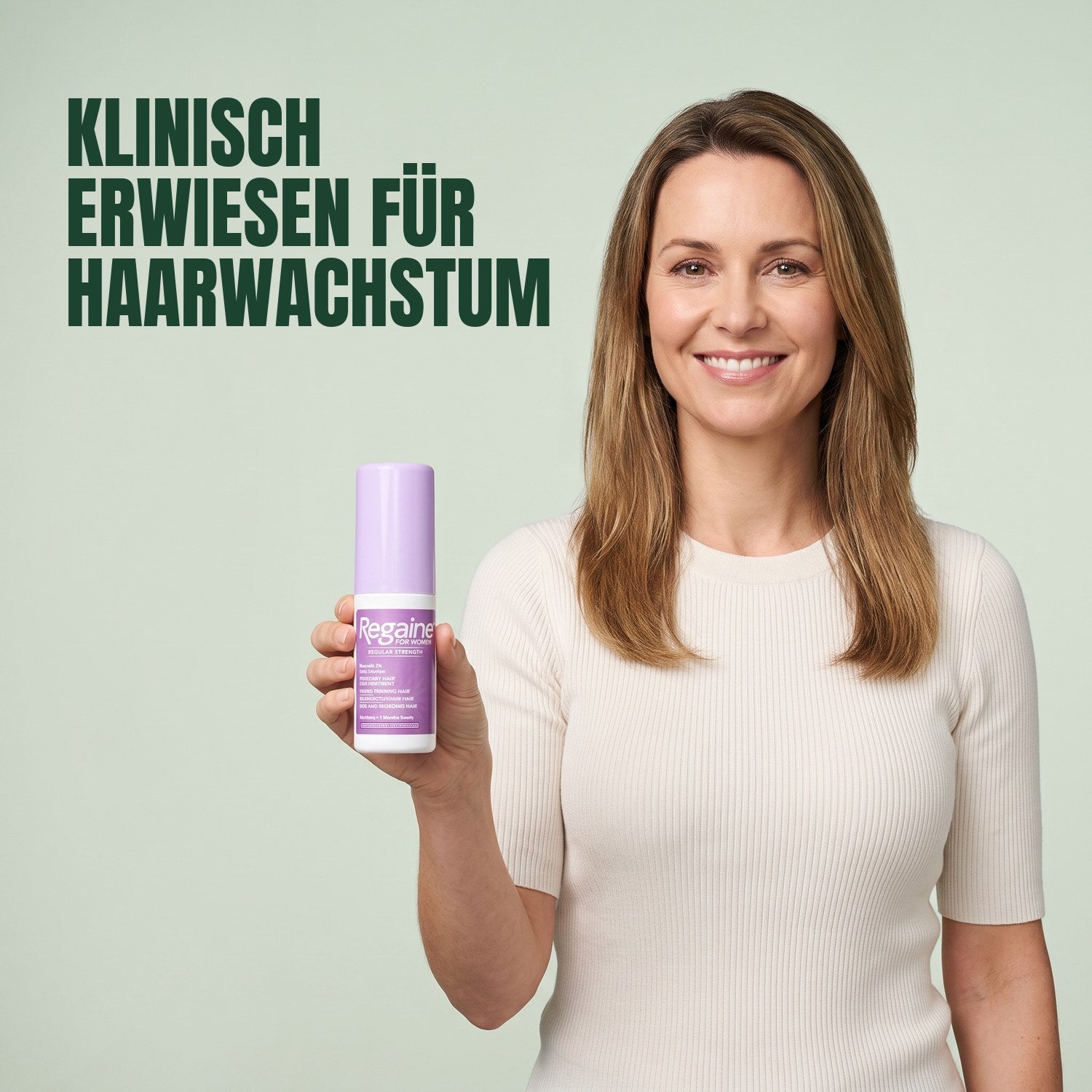 Woman holding a Regaine for Women Minoxidil 2% lotion bottle against a green background