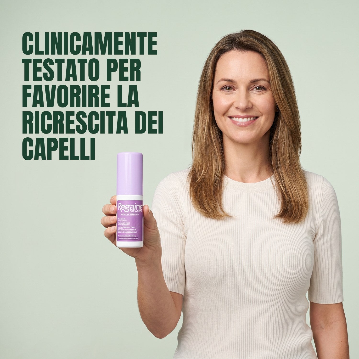 Woman holding a Regaine for Women Minoxidil 2% lotion bottle against a green background
