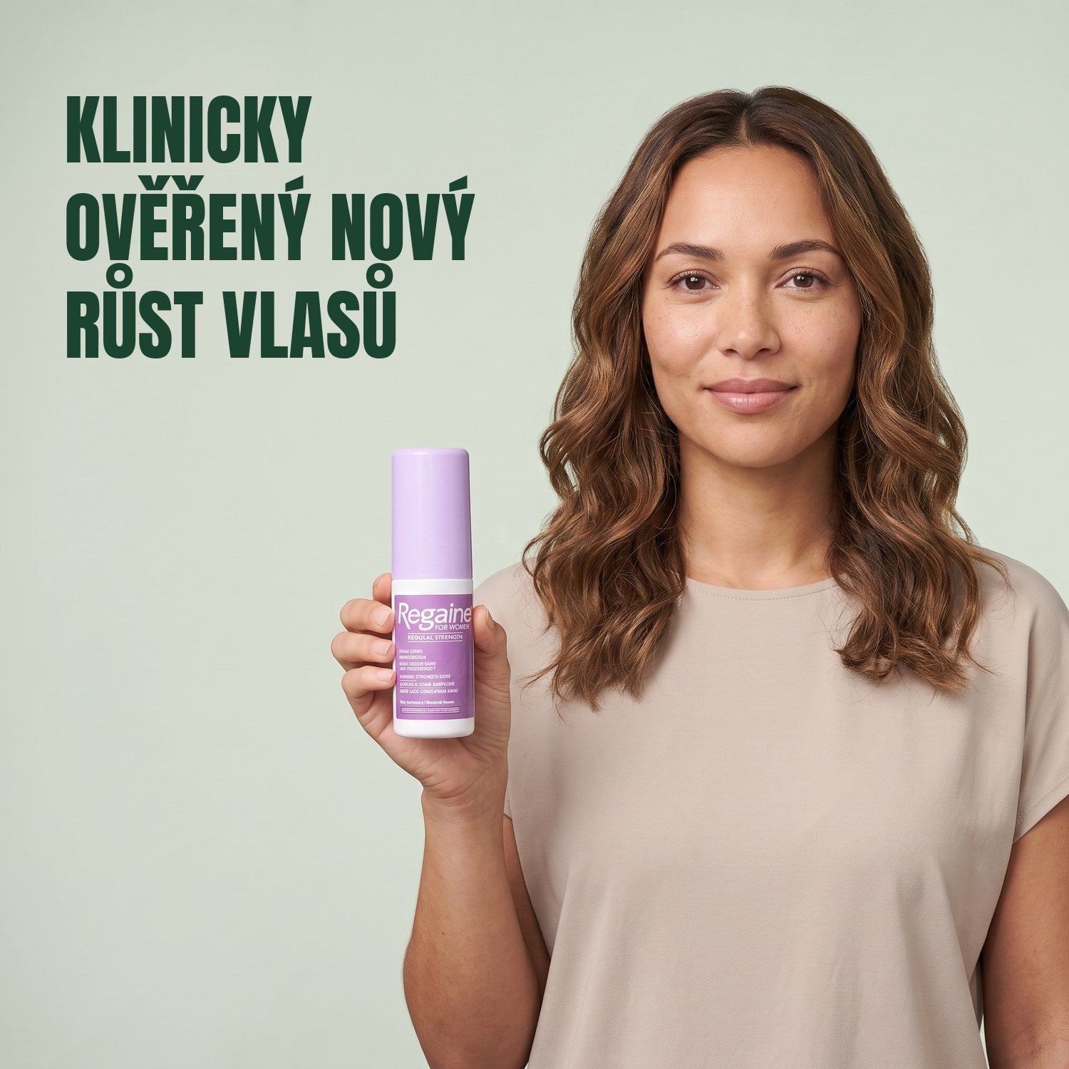 Woman holding the Regaine for Women Minoxidil 2% lotion pack against a green background