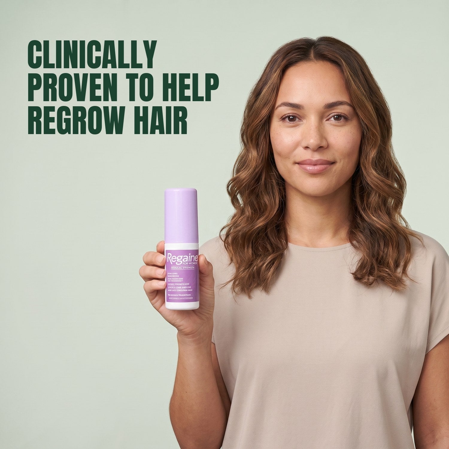 Woman holding the Regaine for Women Minoxidil 2% lotion pack against a green background