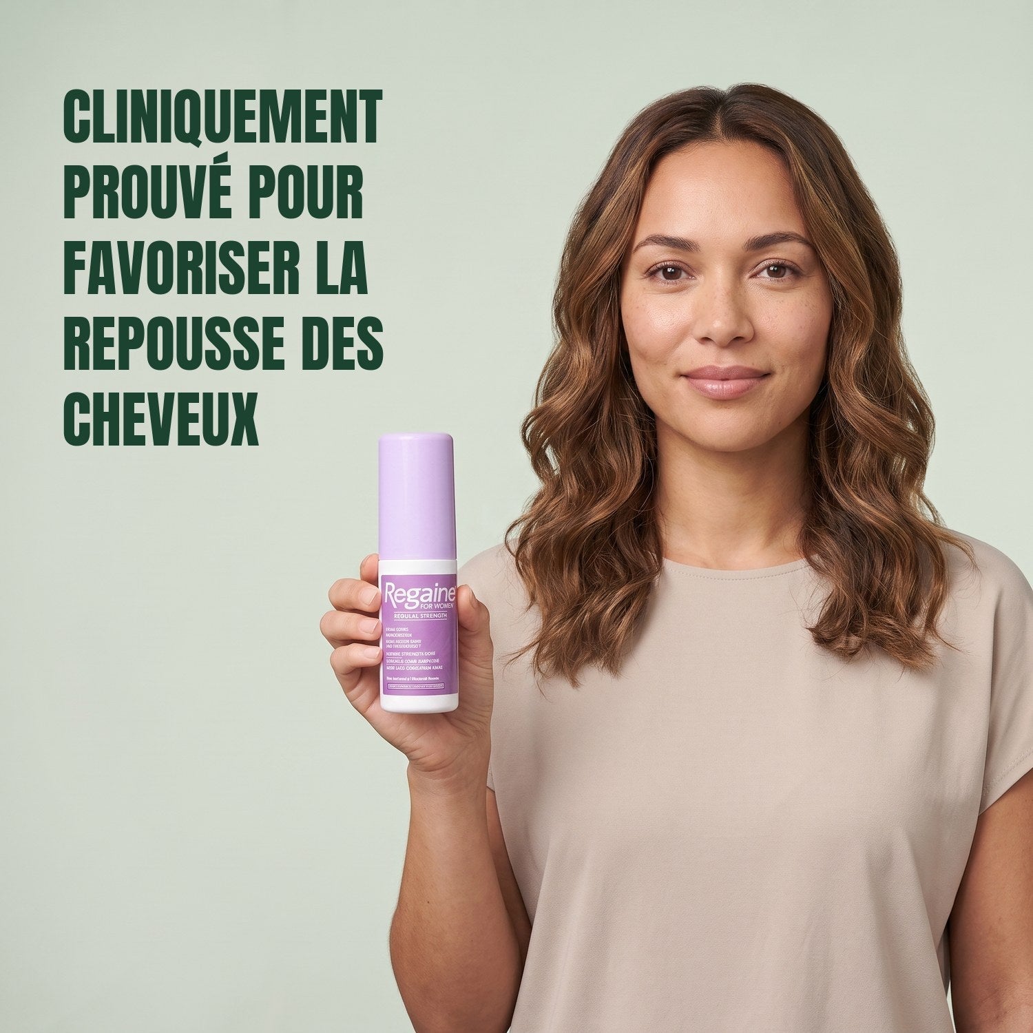 Woman holding the Regaine for Women Minoxidil 2% lotion pack against a green background