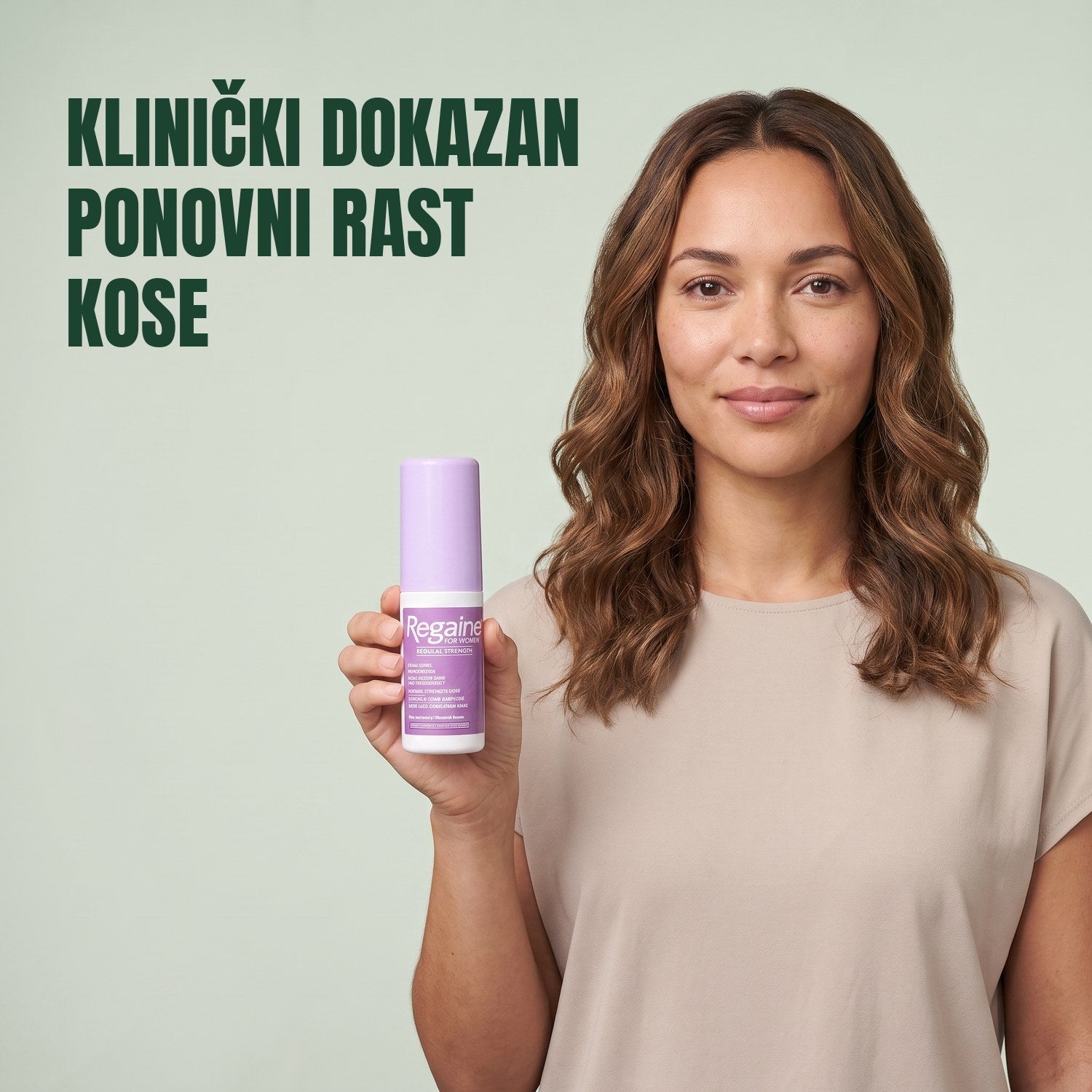 Žena drži pakiranje Regaine for Women Minoxidil 2% losiona na zelenoj pozadini
