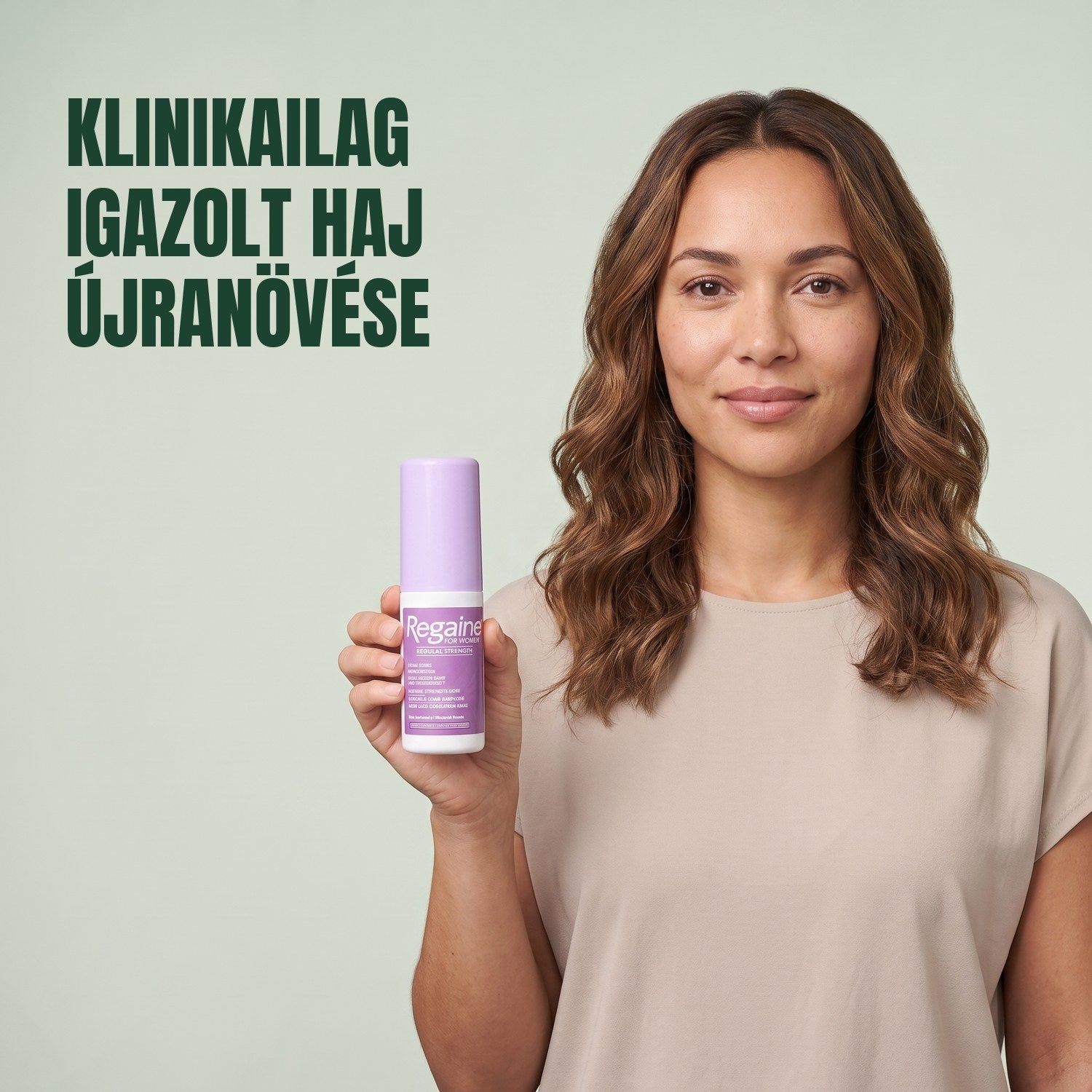 Woman holding the Regaine for Women Minoxidil 2% lotion pack against a green background