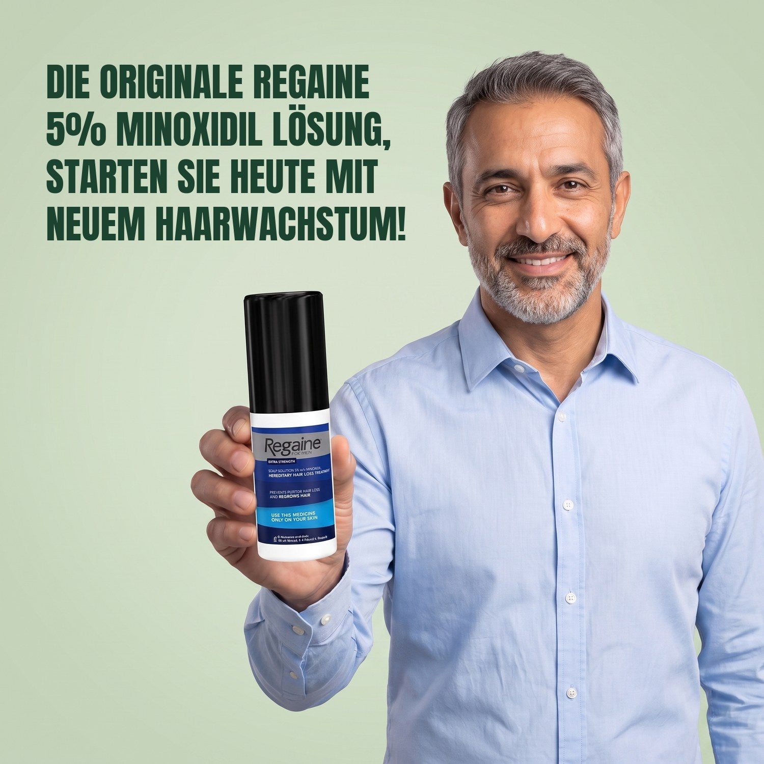 Man holding the Regaine for Men Minoxidil 5% lotion pack against a green background