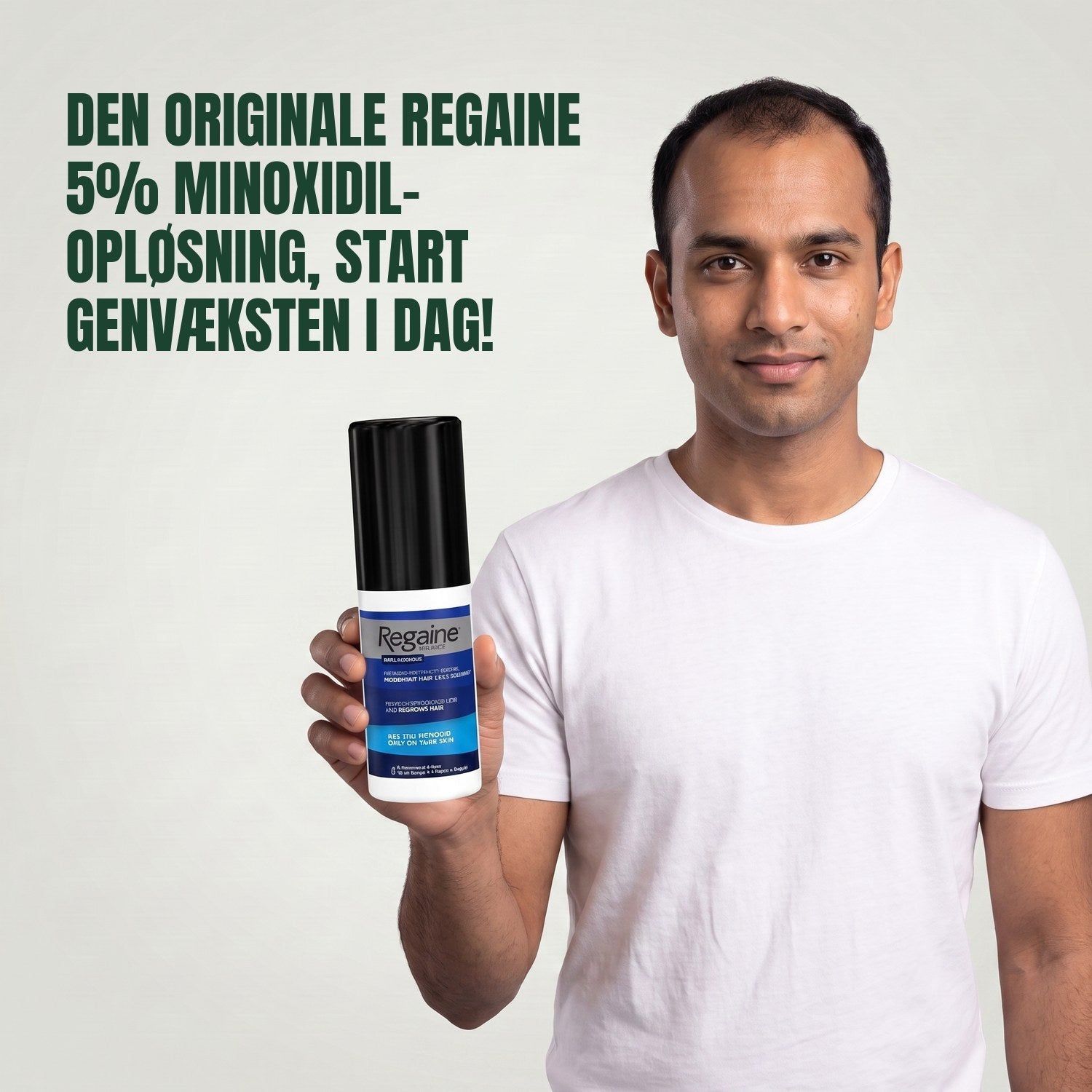 Man holding the Regaine for Men Minoxidil 5% lotion pack against a green background