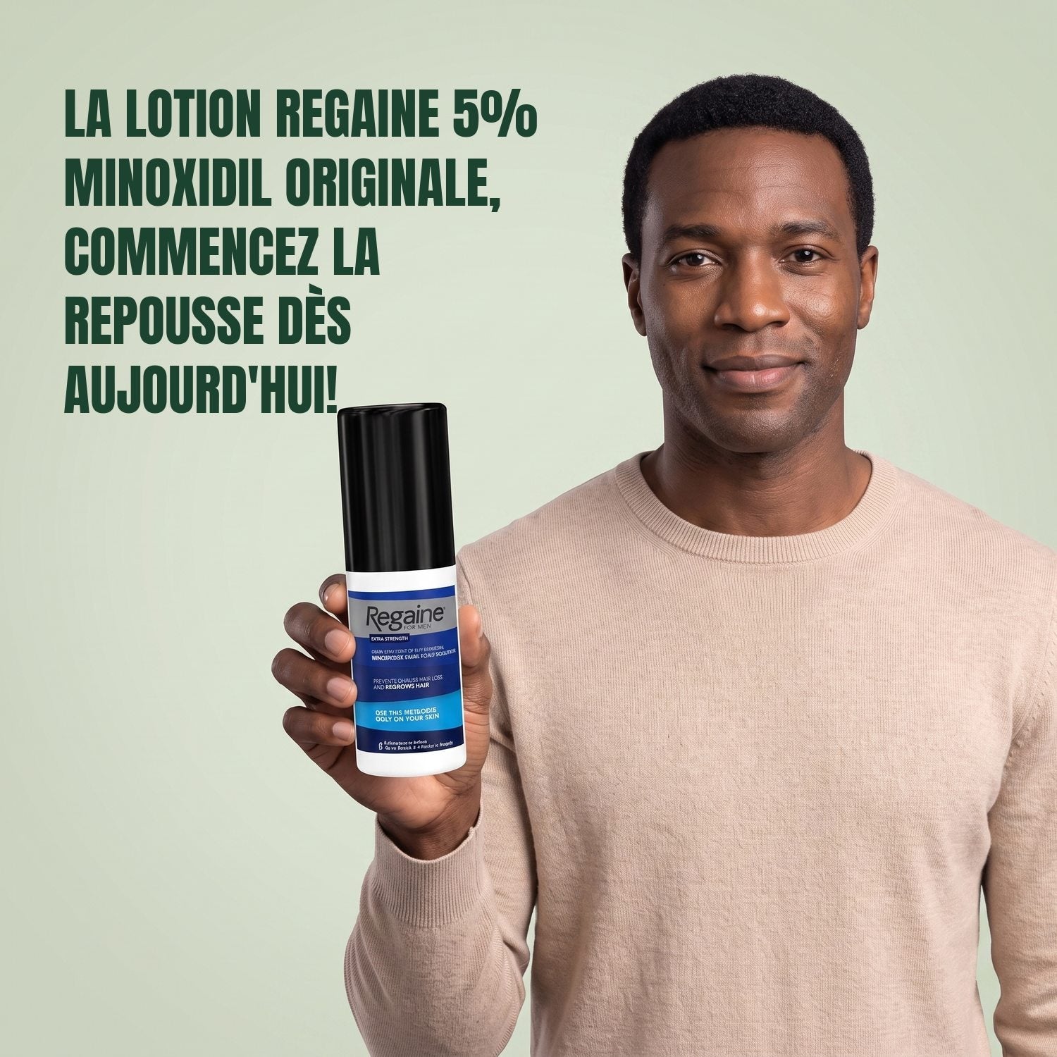 Man holding the Regaine for Men Minoxidil 5% lotion pack against a green background