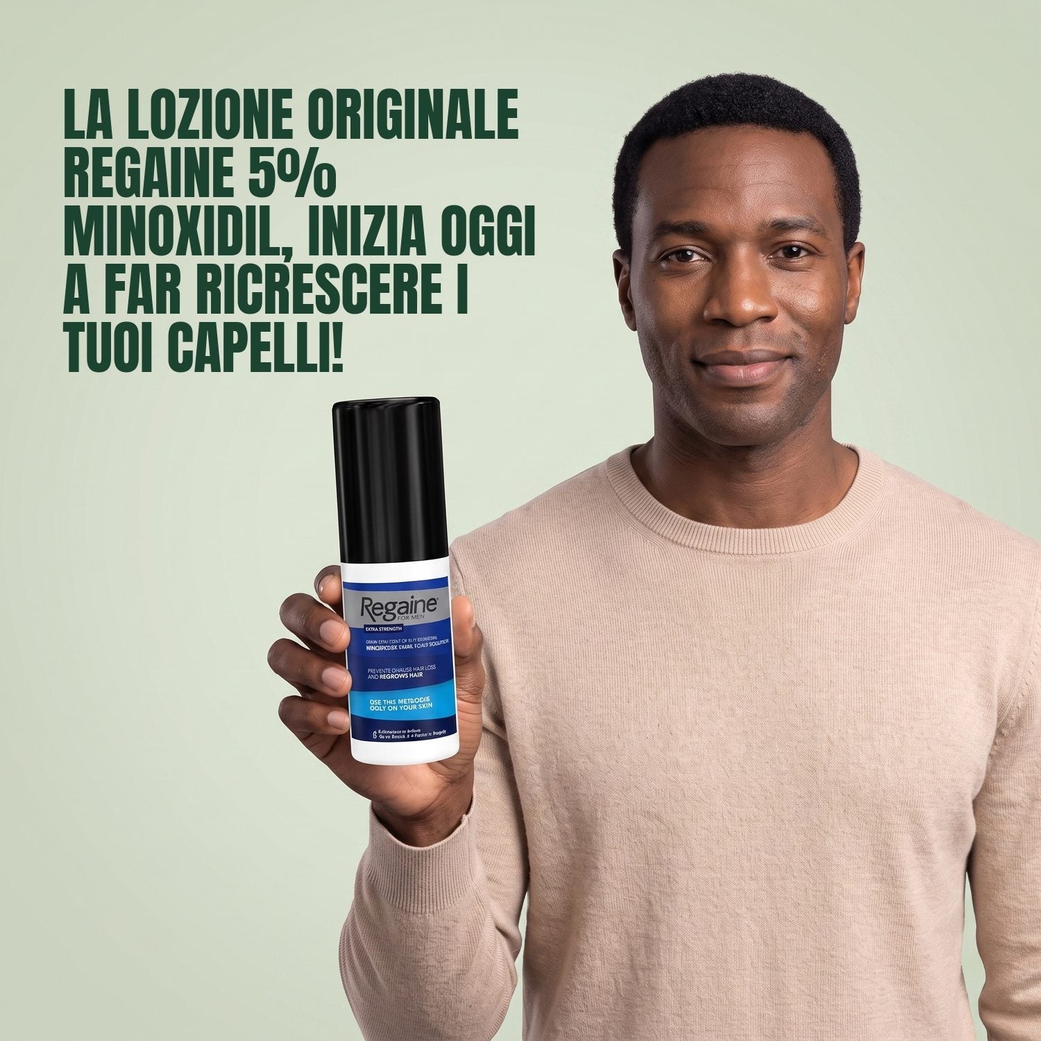 Man holding the Regaine for Men Minoxidil 5% lotion pack against a green background