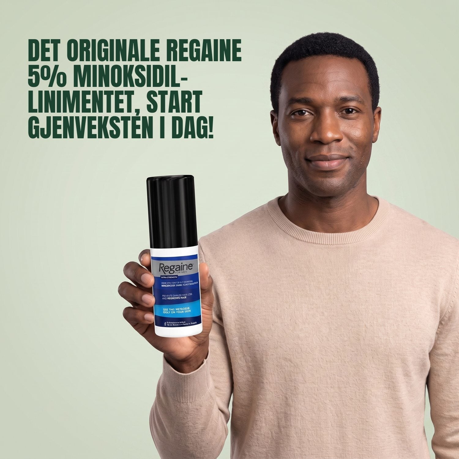 Man holding the Regaine for Men Minoxidil 5% lotion pack against a green background