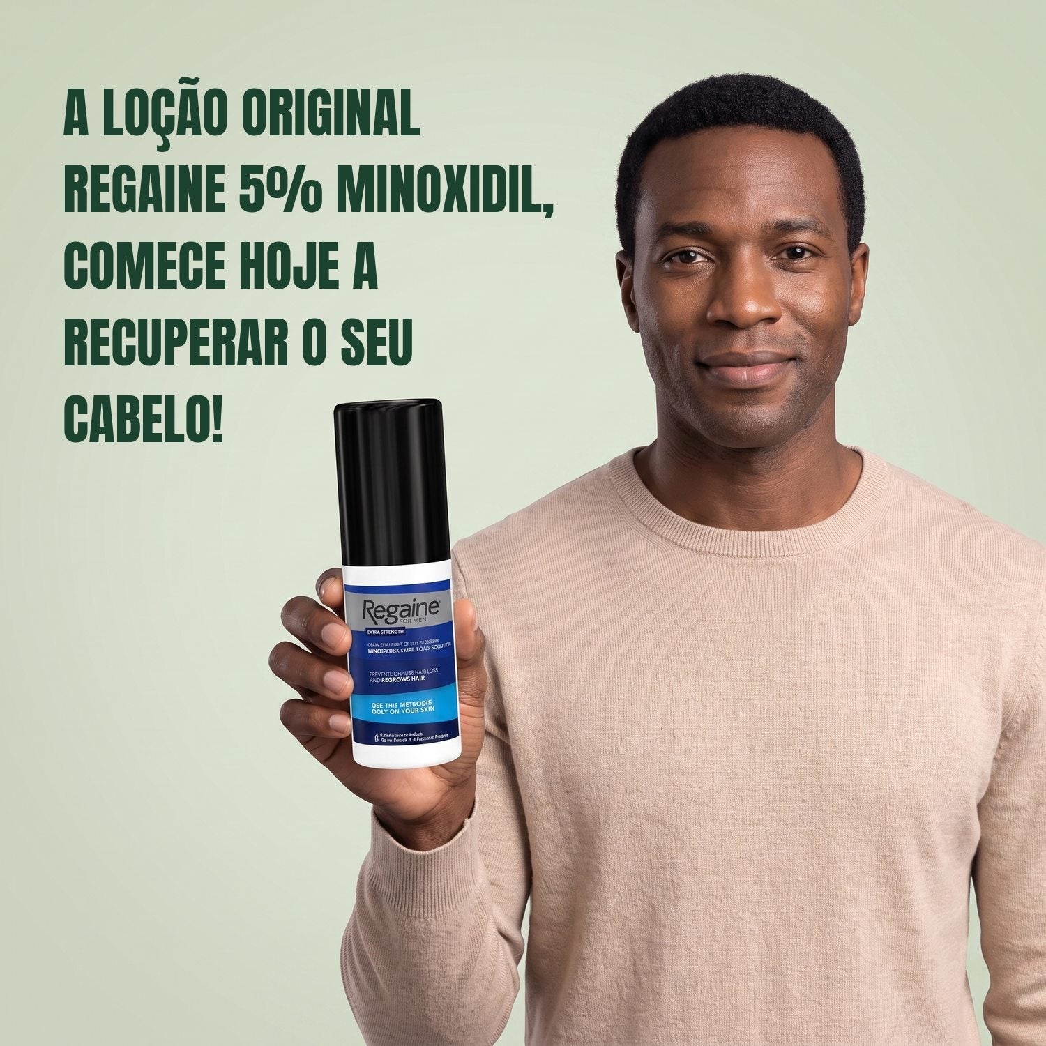 Man holding the Regaine for Men Minoxidil 5% lotion pack against a green background