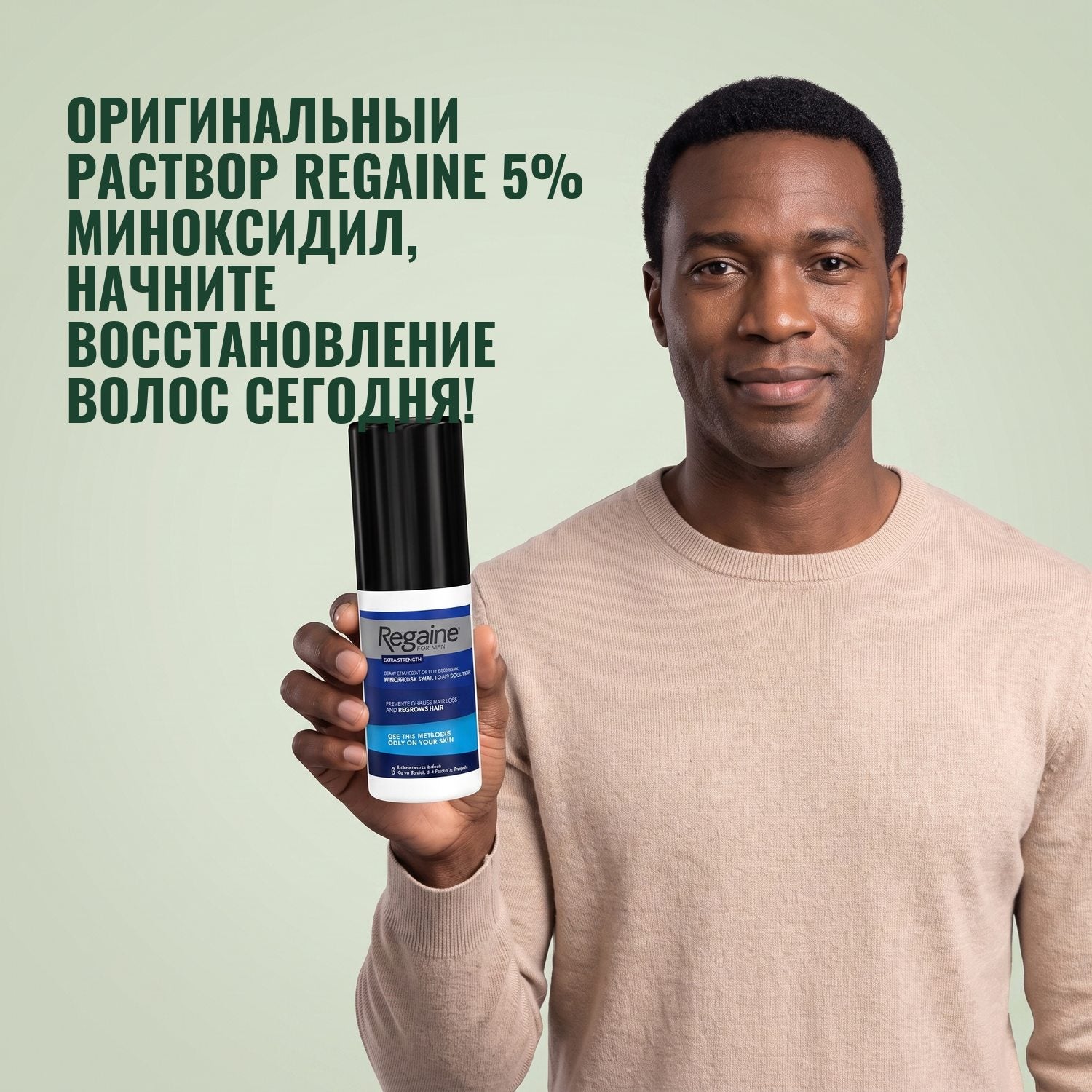 Man holding the Regaine for Men Minoxidil 5% lotion pack against a green background