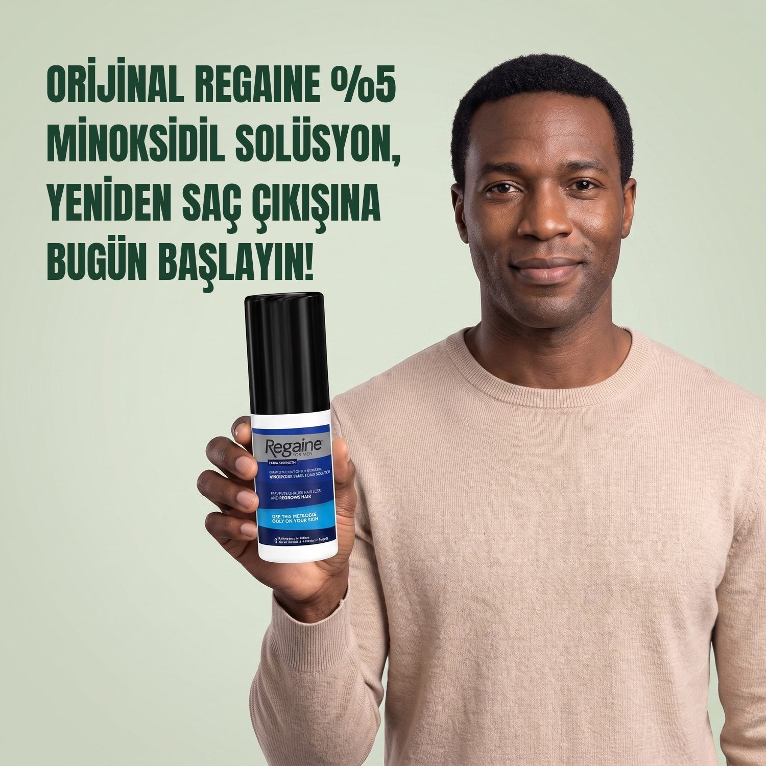 Man holding the Regaine for Men Minoxidil 5% lotion pack against a green background