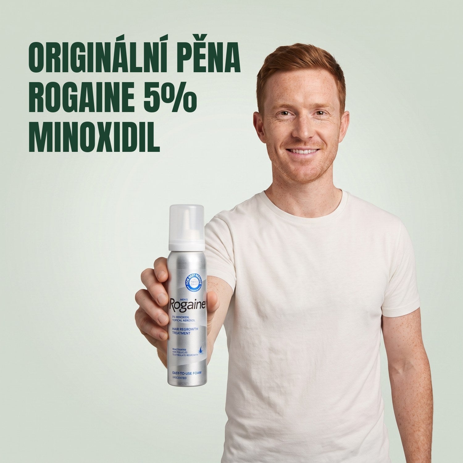 Muž drží plechovku pěny Rogaine 5% minoxidil na zeleném pozadí