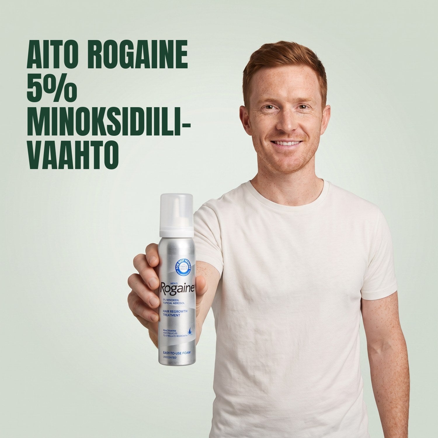 Mies pitelee Rogaine 5% minoksidiili-vaahtopurkkia vihreää taustaa vasten