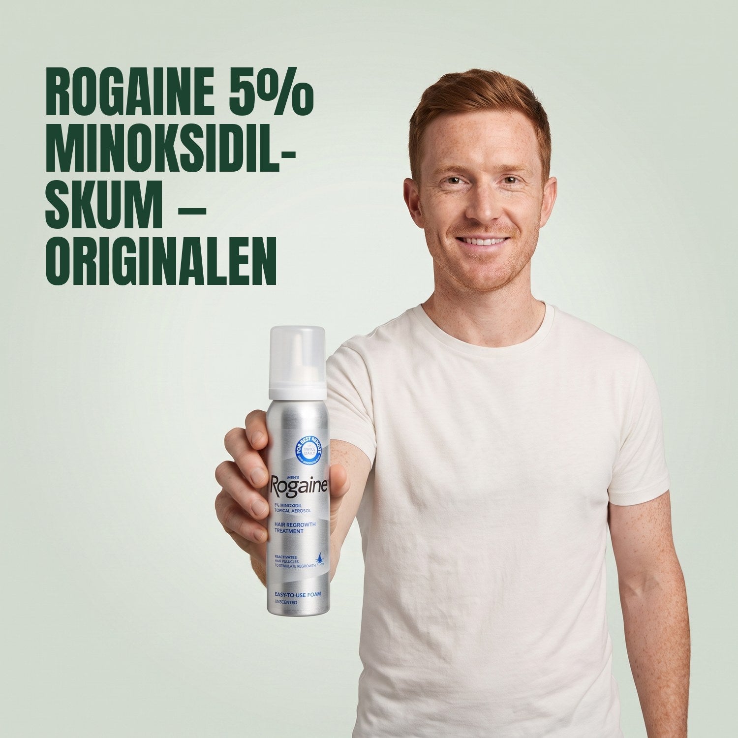 Mann som holder en boks Rogaine 5 % minoksidilskum mot en grønn bakgrunn