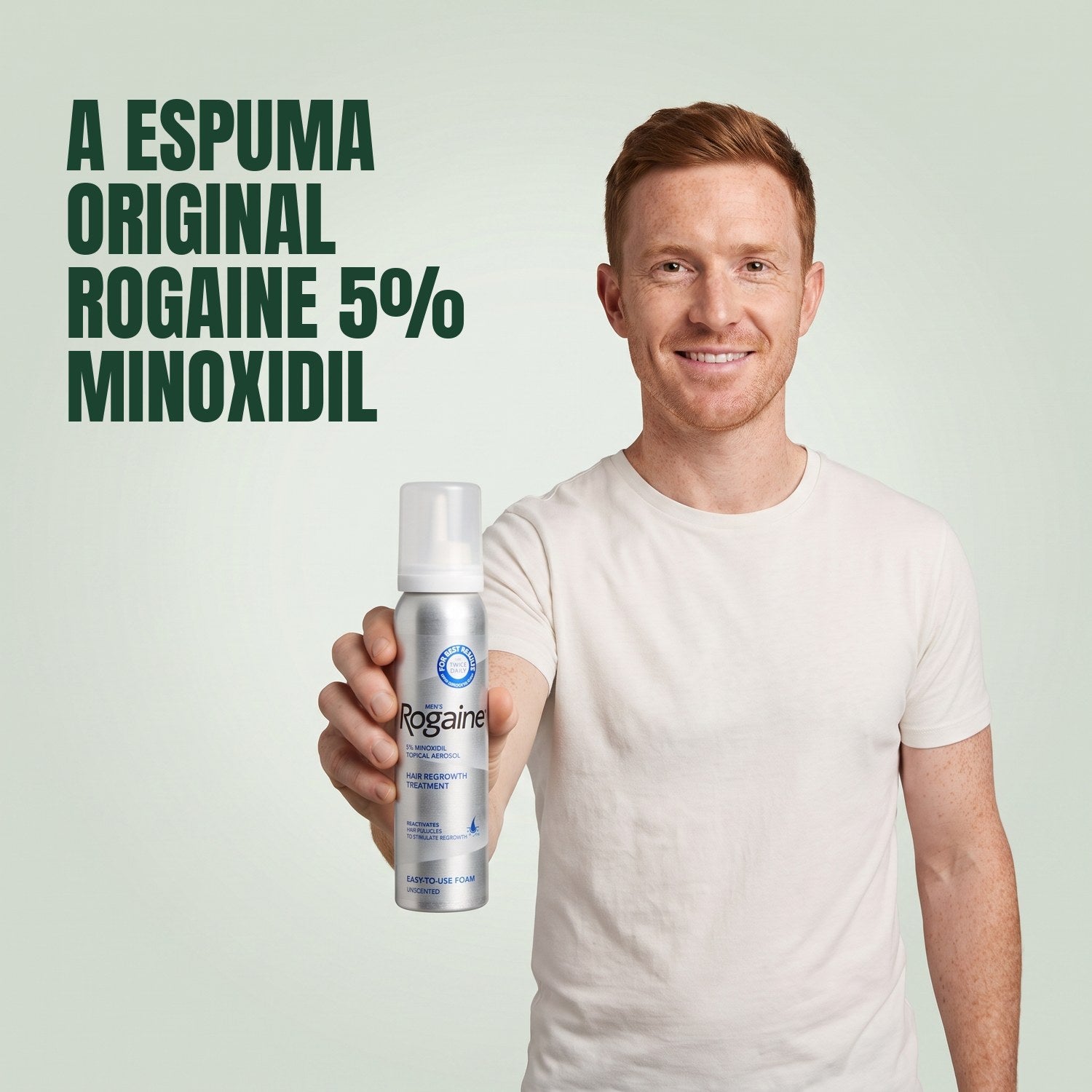 Homem a segurar uma lata de espuma Rogaine minoxidil 5% sobre fundo verde