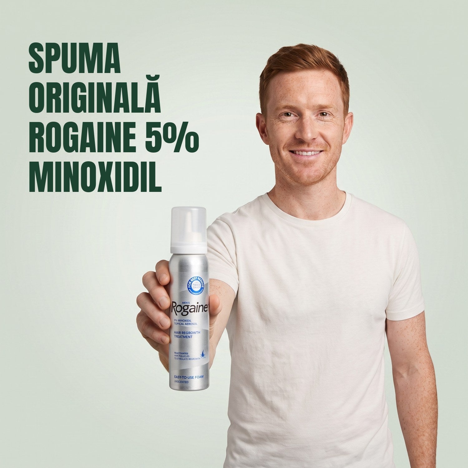 Bărbat ținând o cutie de spumă Rogaine 5% minoxidil pe fundal verde
