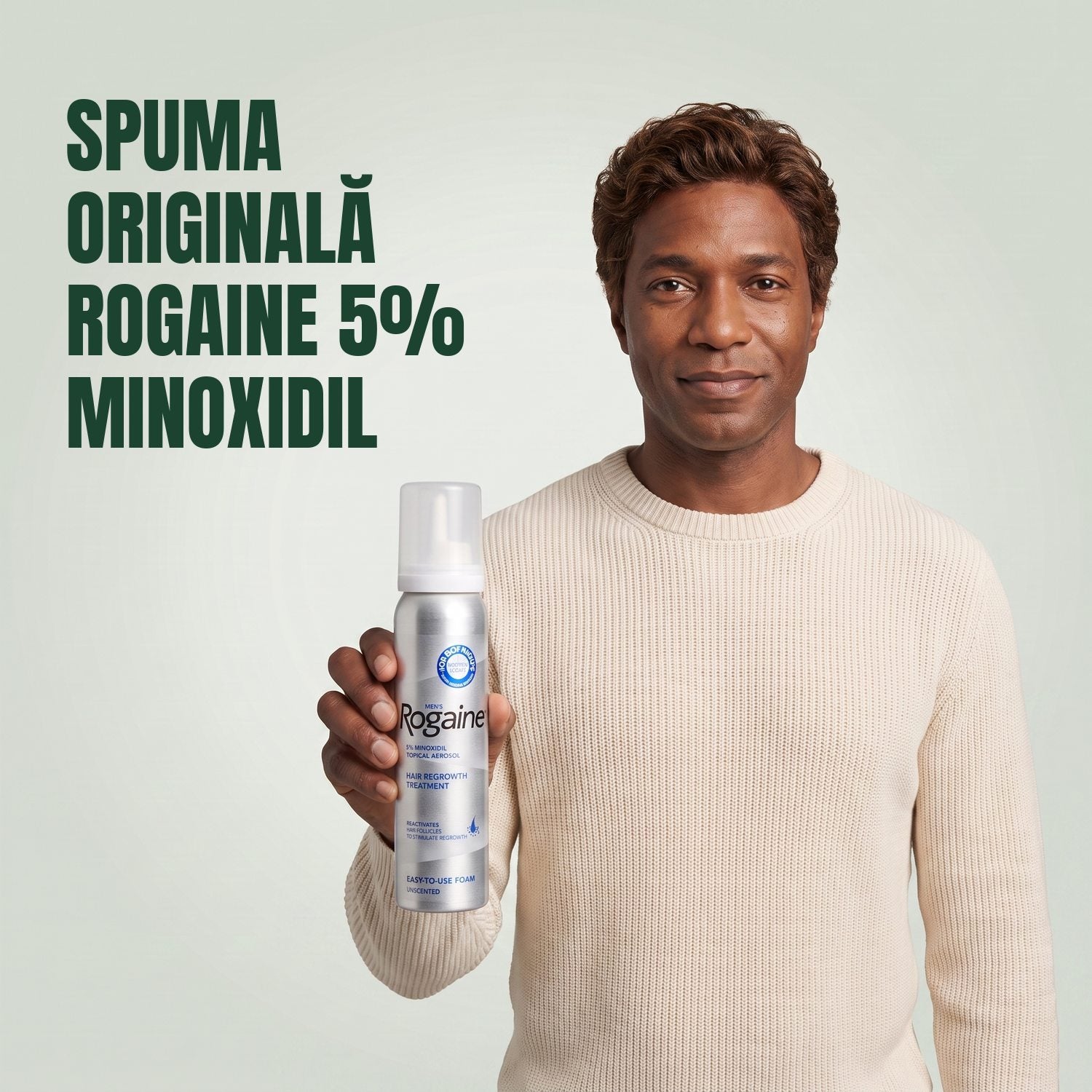Bărbat ținând în mână cutia Rogaine 5% minoxidil spumă, cu o cutie de spumă alături, pe fundal verde