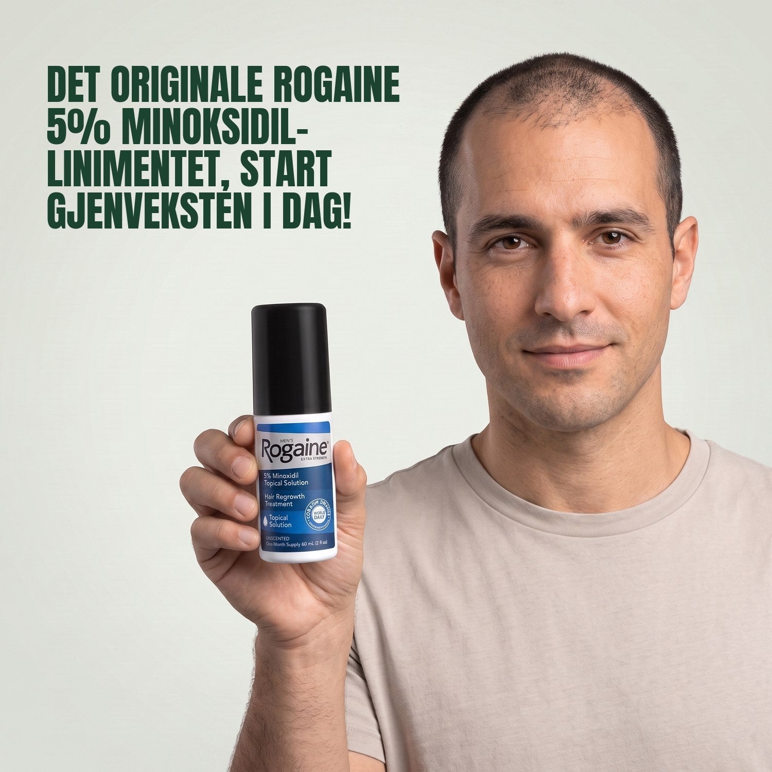 Man holding the Rogaine 5% minoxidil topical solution carton against a green background