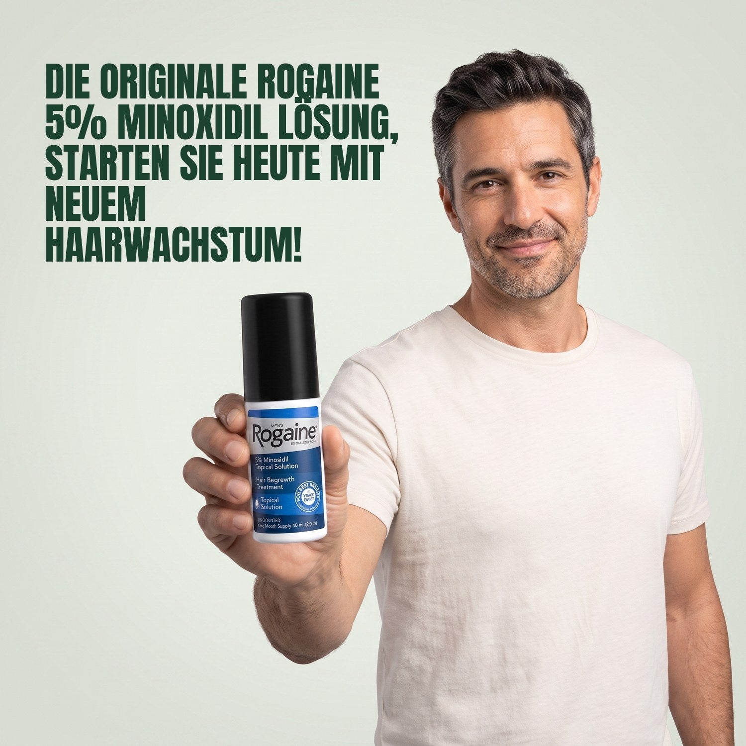 Man holding a Rogaine 5% minoxidil topical solution bottle against a green background