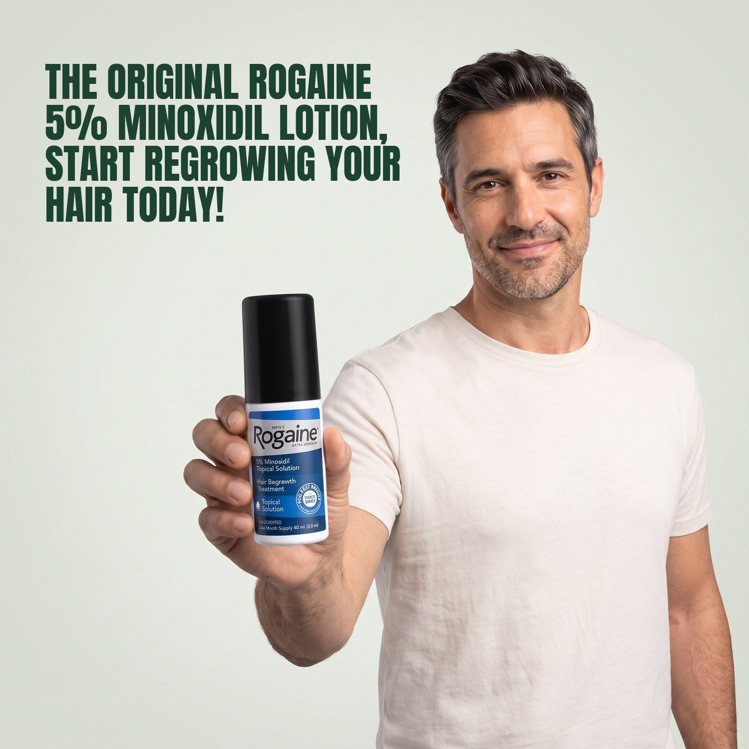 Man holding a Rogaine 5% minoxidil topical solution bottle against a green background