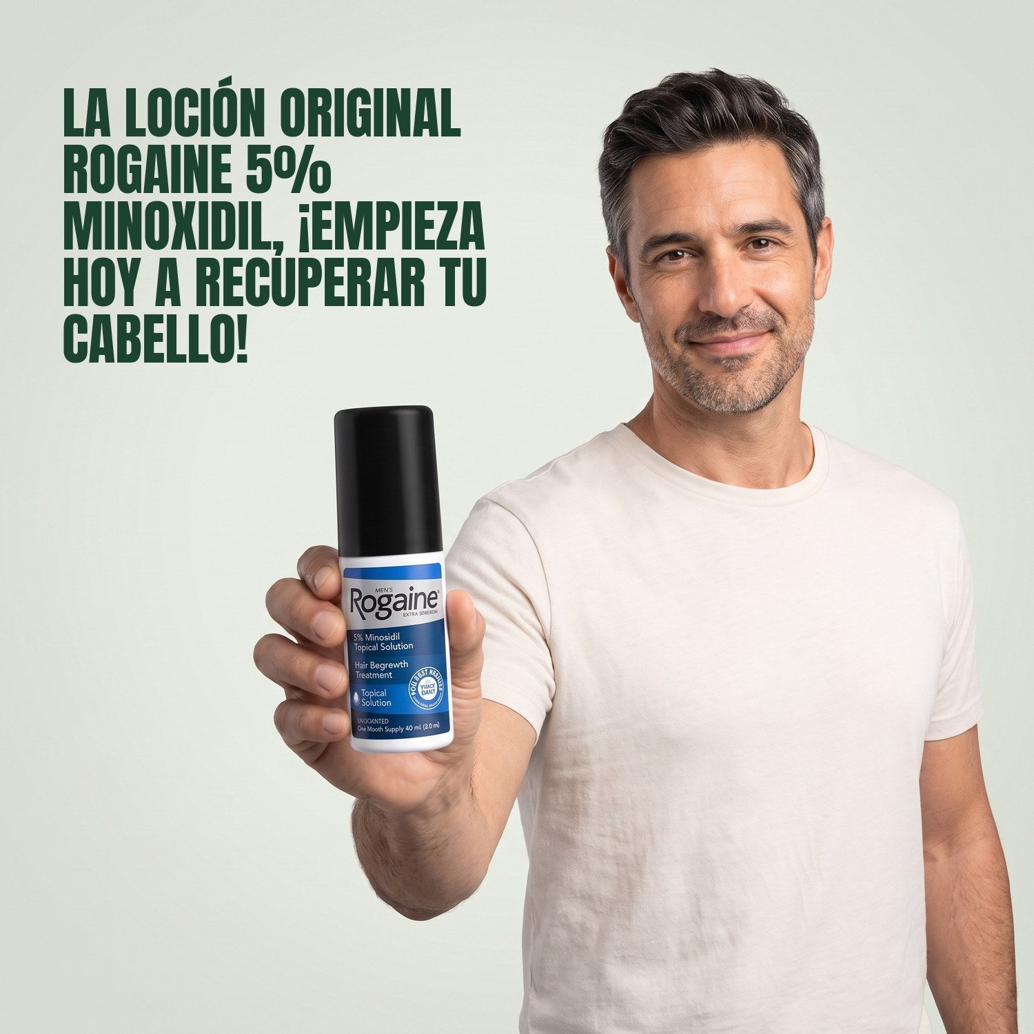 Man holding a Rogaine 5% minoxidil topical solution bottle against a green background