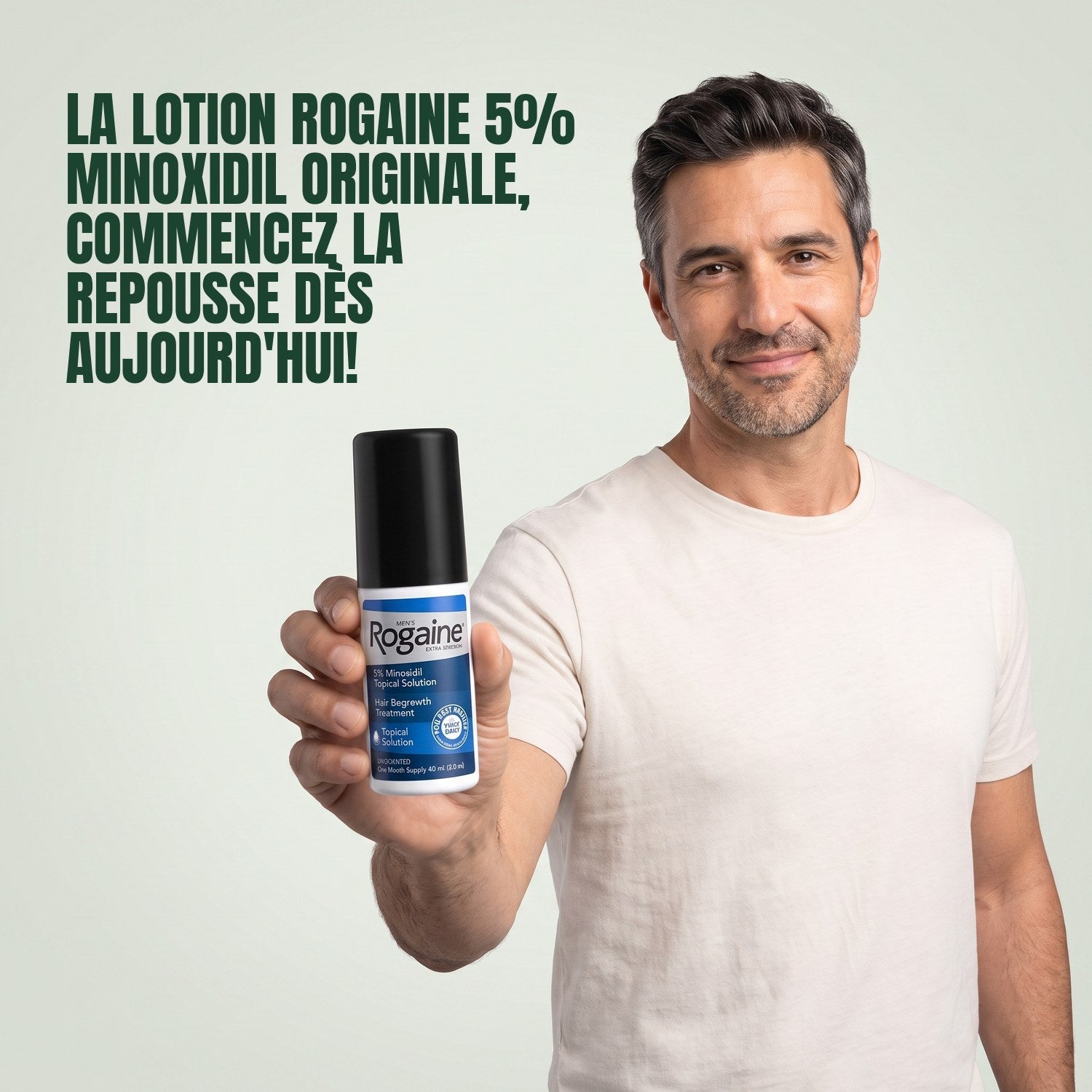 Man holding a Rogaine 5% minoxidil topical solution bottle against a green background